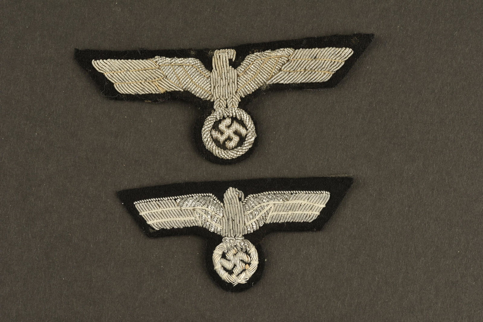 Kriegsmarine officer insignia: Comprenant un aigle de coiffure en cannetille argent et un aigle de poitrine en cannetille argent. Jamais montes. A noter une legere usure et patine des piÃ¨ces. Comprising a silver cannetille headd