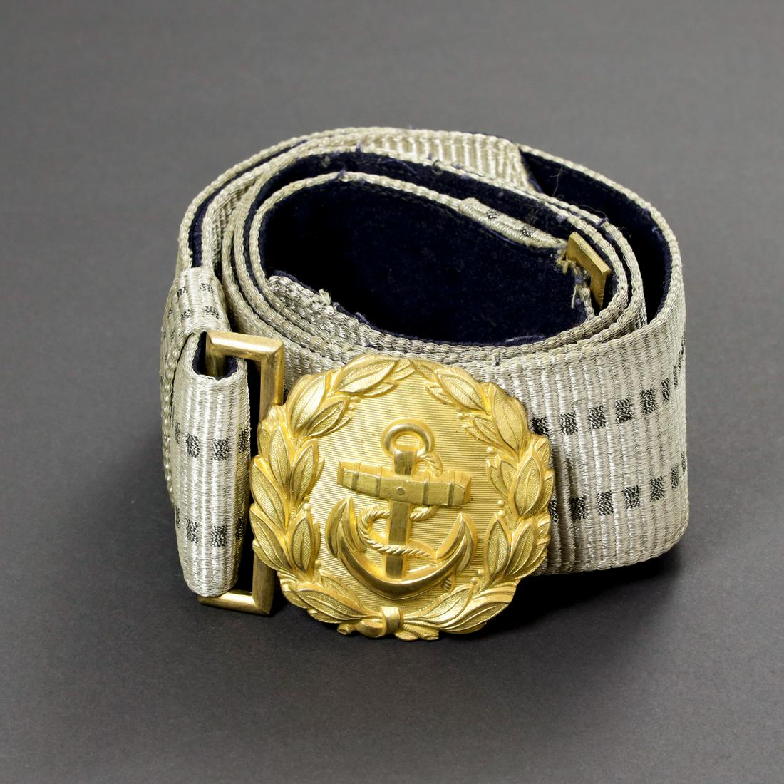Kriegsmarine officer brocade. Feldbinde officier km: Ceinturon en fil argent et gris. Doublure en drap bleu marine. Boucle de ceinturon en metal dorÃe. Sans marquages visibles. A noter une certaine usure et patine de la piece. Belt in silver and gray t