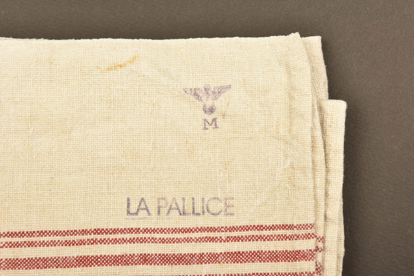 Torchon Kriegsmarine La Palice. KM towel La Palice: En tissu coton gris Ã bandes rouges. Beau tampon de la Kriegsmarine et mention La Palice. A noter une certaine usure de la piÃ¨ce, ainsi que des tÃ¢ches. In gray cotton fabric with red stripes.