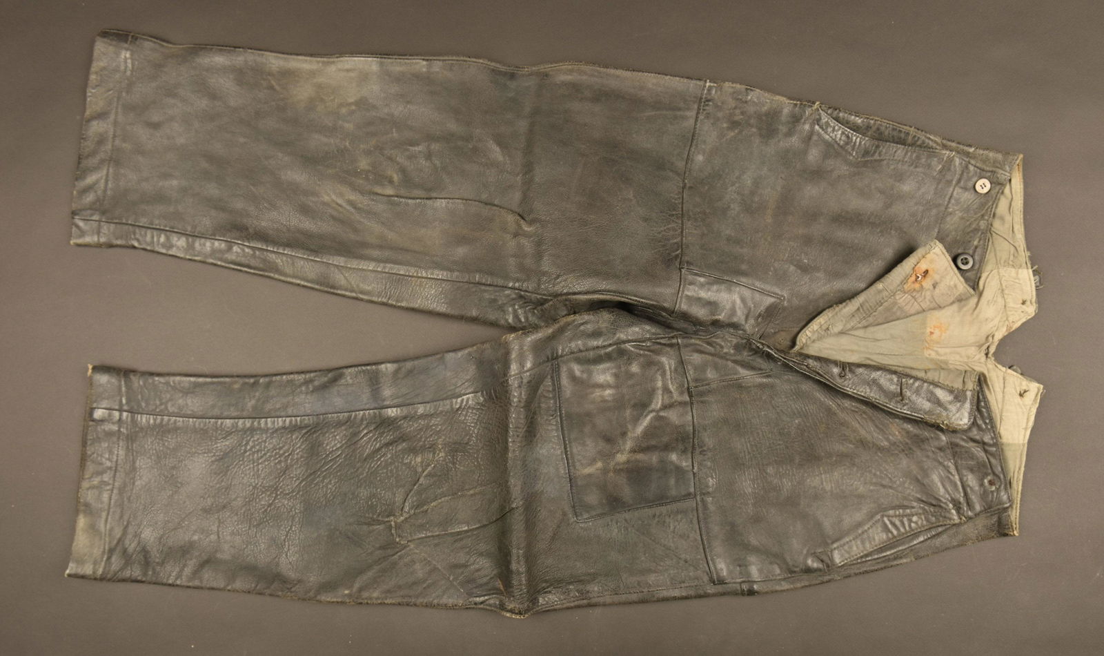 KM leather pants. Pantalon cuir Kriegsmarine: En cuir noir, la majoritÃ© des boutons sont manquants. IntÃ©rieur doublÃ© en tissu coton gris. Sans marquages visibles. A noter une forte usure et patine de la piÃ¨ce. Selon les informations d