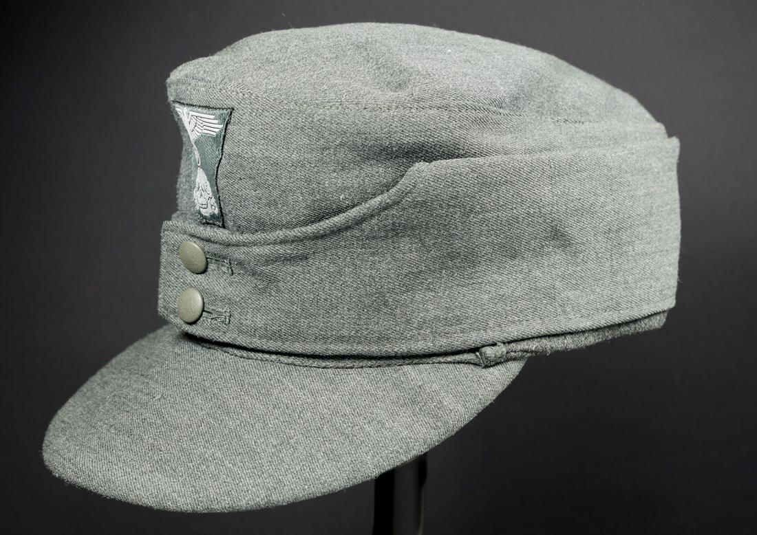 Casquette Modele 43 de la Waffen SS. Waffen SS M-43 cap: En tissu gabardine italien. Deux boutons greneles en couleur d'origine. Insigne Bevo trapezoidal monte machine. Interieur doublÃe en tissu gris. Marquages H43. Taille 56. A noter une legere usure et
