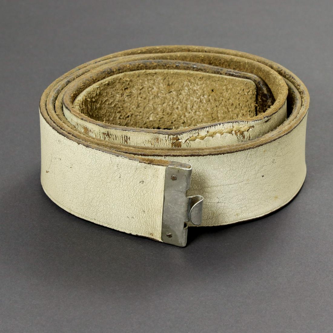 Ceinturon blanc de la Waffen SS. Waffen SS white belt.: En cuir recouvert d'une couleur blanche. Patte de reglage presente. Taille 110. Tampon RZM SS presents. A noter une certaine usure et patine de la piece. Leather covered in white color. Adjustment tab