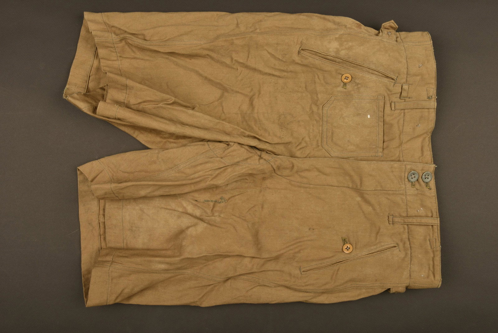 Short tropical de la Waffen SS. Tropical shorts from: En tissu coton de couleur sable. Tous les boutons sont prÃ©sents. Marquages Neuerner Waeschefabrik, taille 8426. A noter une certaine usure et patine de la piÃ¨ce, ainsi que quelques tÃ¢ches. In