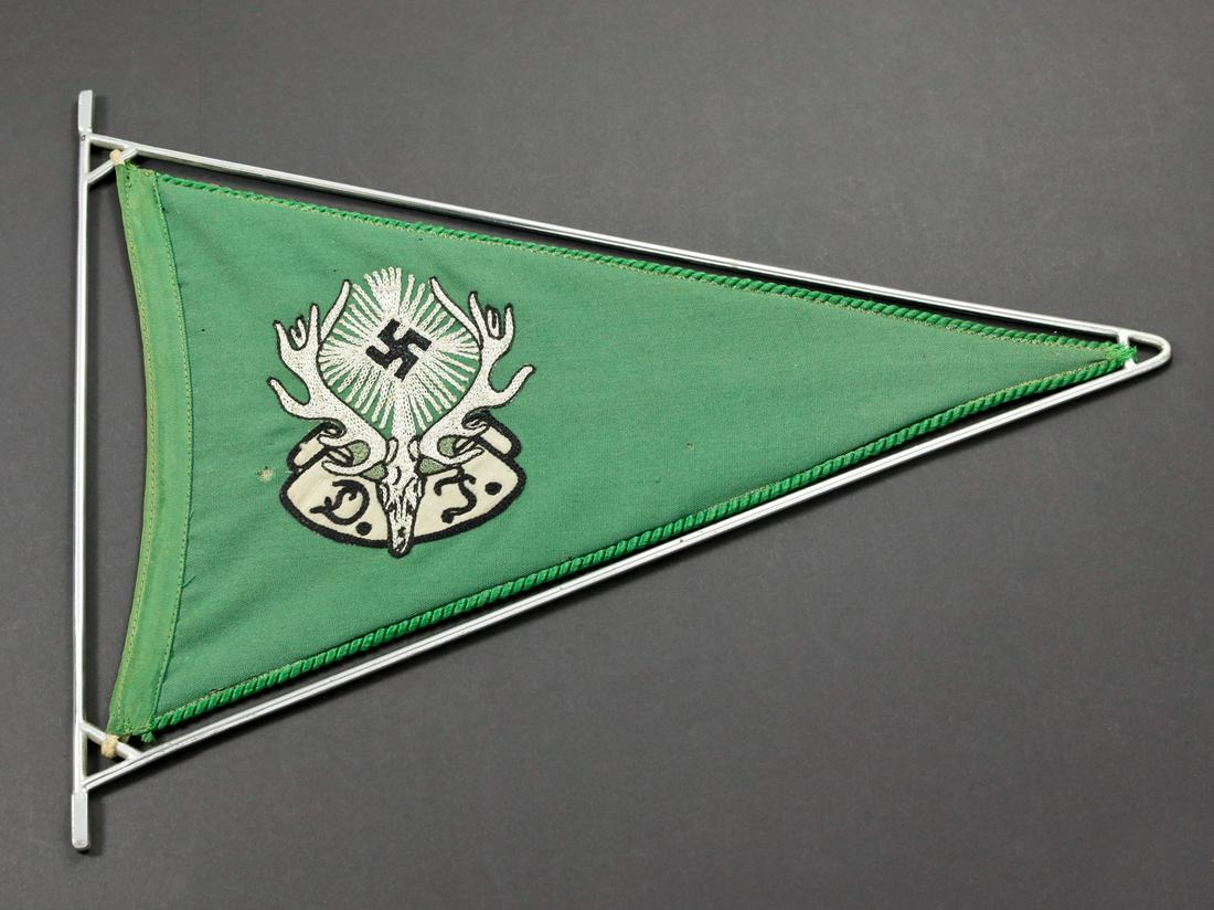 Fanion de vehicule du Deutsche Jagerschaft. Deutsche: Armature en mÃ©tal nickelÃ©. Fanion en tissu coton vert, liserÃ© vert sur les trois bordures du fanion. Insigne du Deutsche JÃ¤gerschaft brodÃ©. Biface. A noter une certaine usure et patine