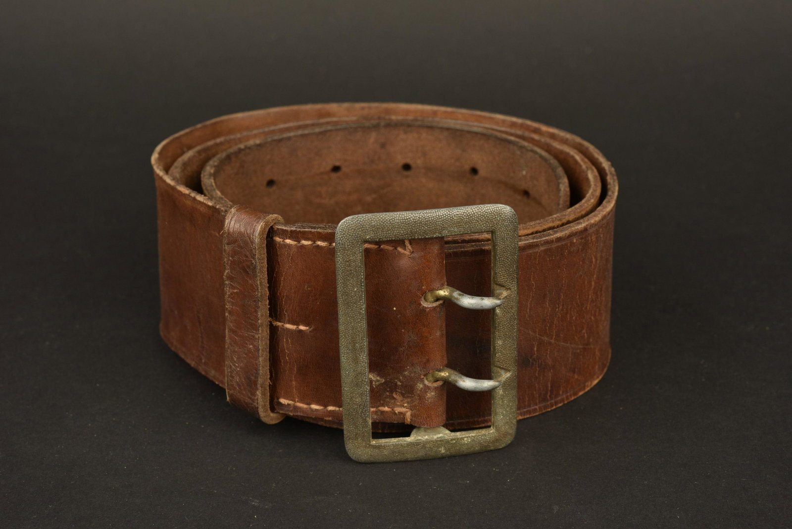 Ceinturon RZM. RZM belt.: En large cuir marron. Boucle en mÃ©tal grenelÃ© Ã deux ardillons, marquages prÃ©sents mais illisibles, couleur d'origine Ã 80%. Cuir marquÃ© KernstÃ¼ck RZM L4/138/38. Passant en cuir p
