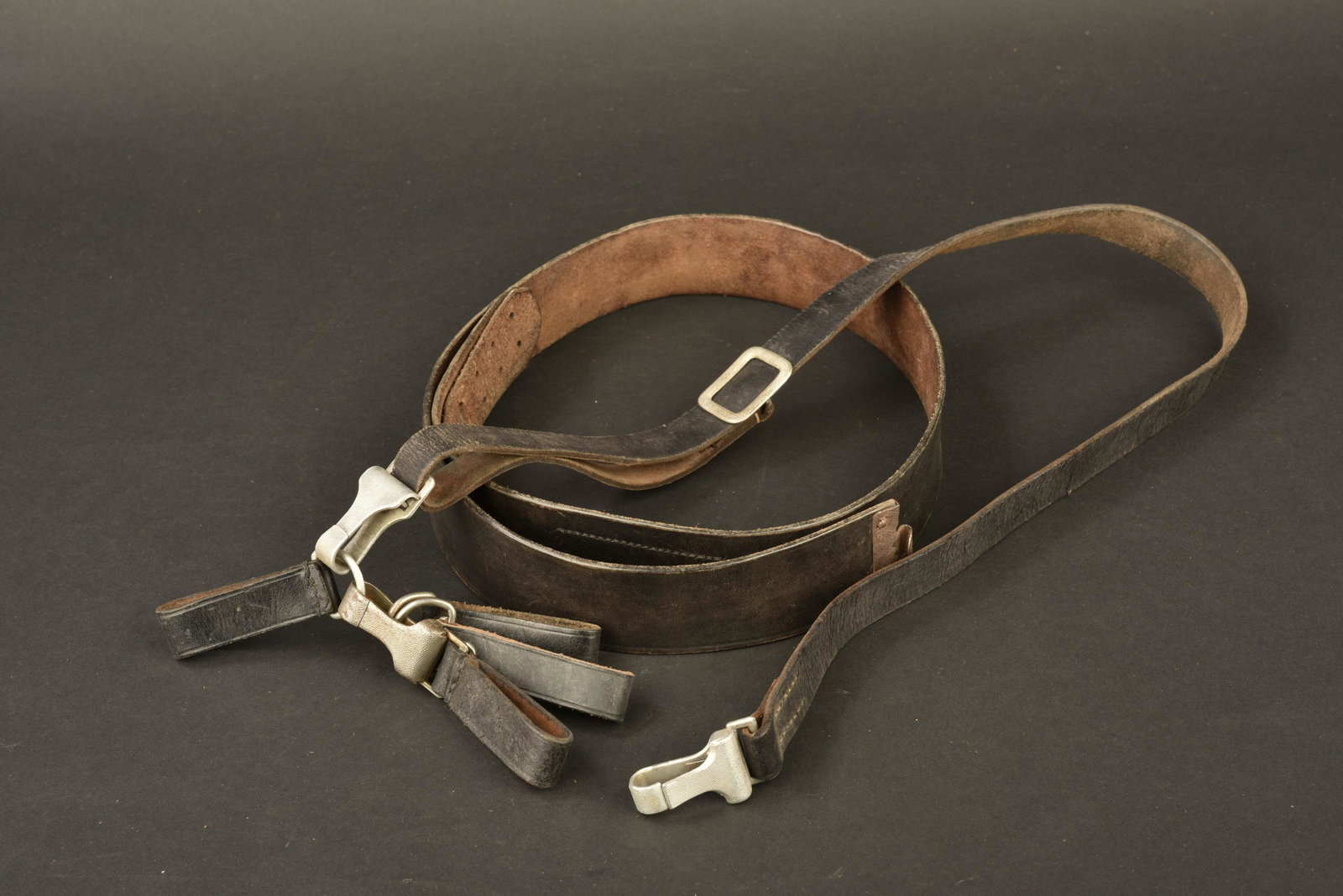 Ceinturon et baudrier allemand. German belt and harness: Ceinturon en cuir noir, sans marquages visibles, bouclerie oxydÃ©e. Baudier en cuir noir, mousquetons en aluminium, fabrication Assmann DRGM. Les passants de ceinturon sont prÃ©sents. A noter une 