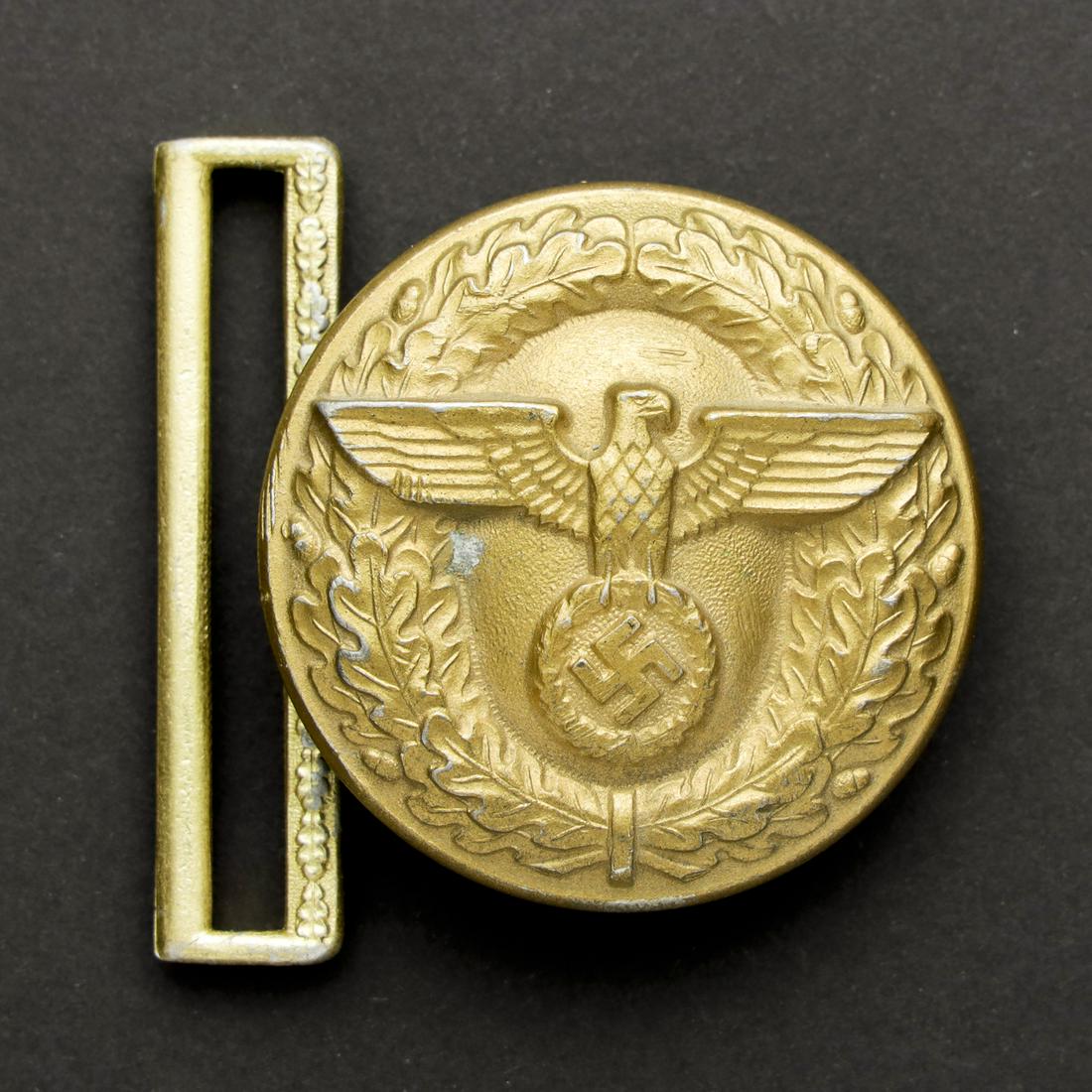 Boucle de ceinturon Politischer Leiter.: En mÃ©tal dorÃ©. Dorure Ã 80%. Fabrication RZM M4/24, correspondant au fabricant Friedrich Linden LÃ¼denscheid. A noter une certaine usure et patine de la piÃ¨ce. In gold-tone metal. 80% gi