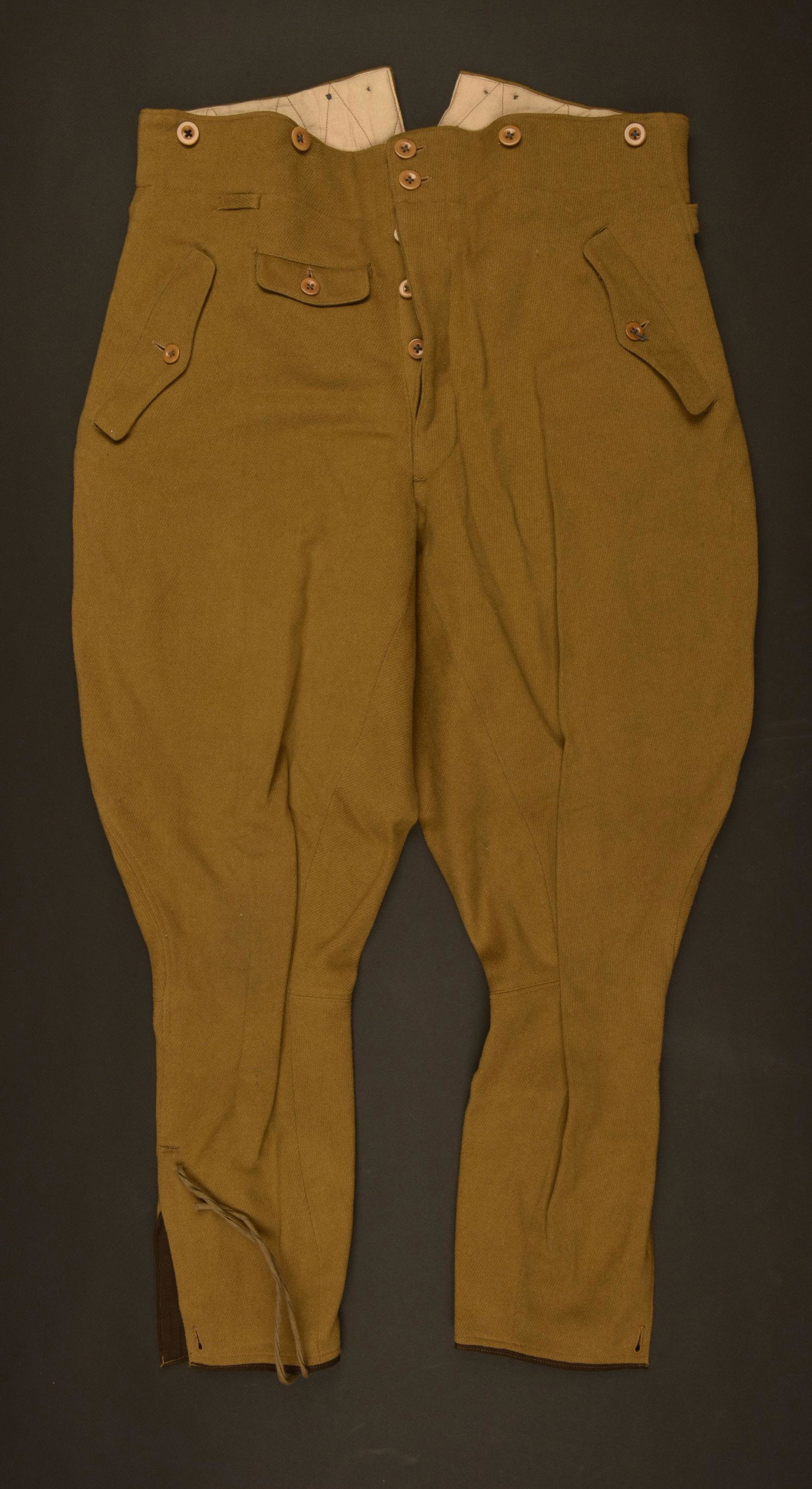 Pantalon culotte de cheval de Politischerleiter.: En drap marron, tous les boutons sont prÃ©sents. Deux poches de hanche sous rabat. Bas des jambes fermant par un laÃ§age. IntÃ©rieur doublÃ© en tissu saumon. Indication au tampon d'une taille