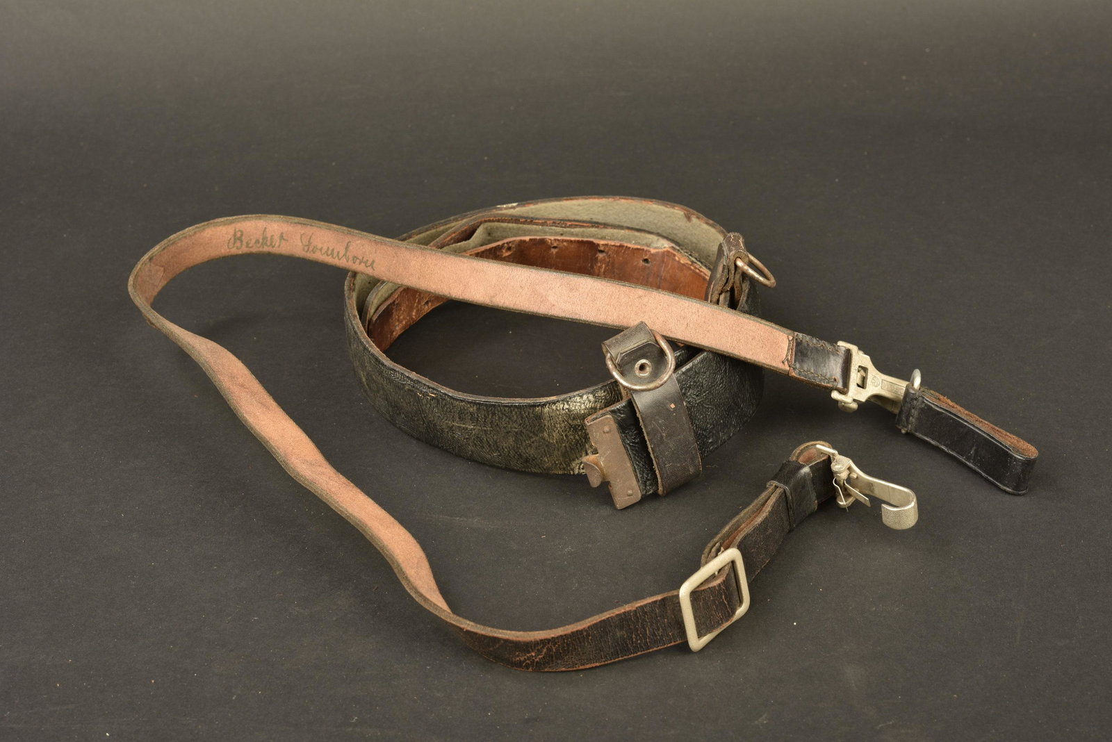 Ceinturon et baudrier allemand. German belt and: Ceinturon en cuir noir doublÃ© de drap fortement mitÃ©, sans marquages visibles, bouclerie oxydÃ©e. Baudrier en cuir noir, mousquetons en aluminium, fabrication Assmann DRGM. Un mousqueton cass�