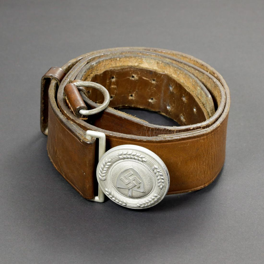 Ceinturon officier RAD. RAD officer belt: Ceinturon en cuir marron, les passants sont prÃ©sents. Taille 95, doublure manquante. Boucle en aluminium complÃ¨te. Fabrication Assmann DRGM 38. A noter une certaine usure et patine de la piÃ¨c