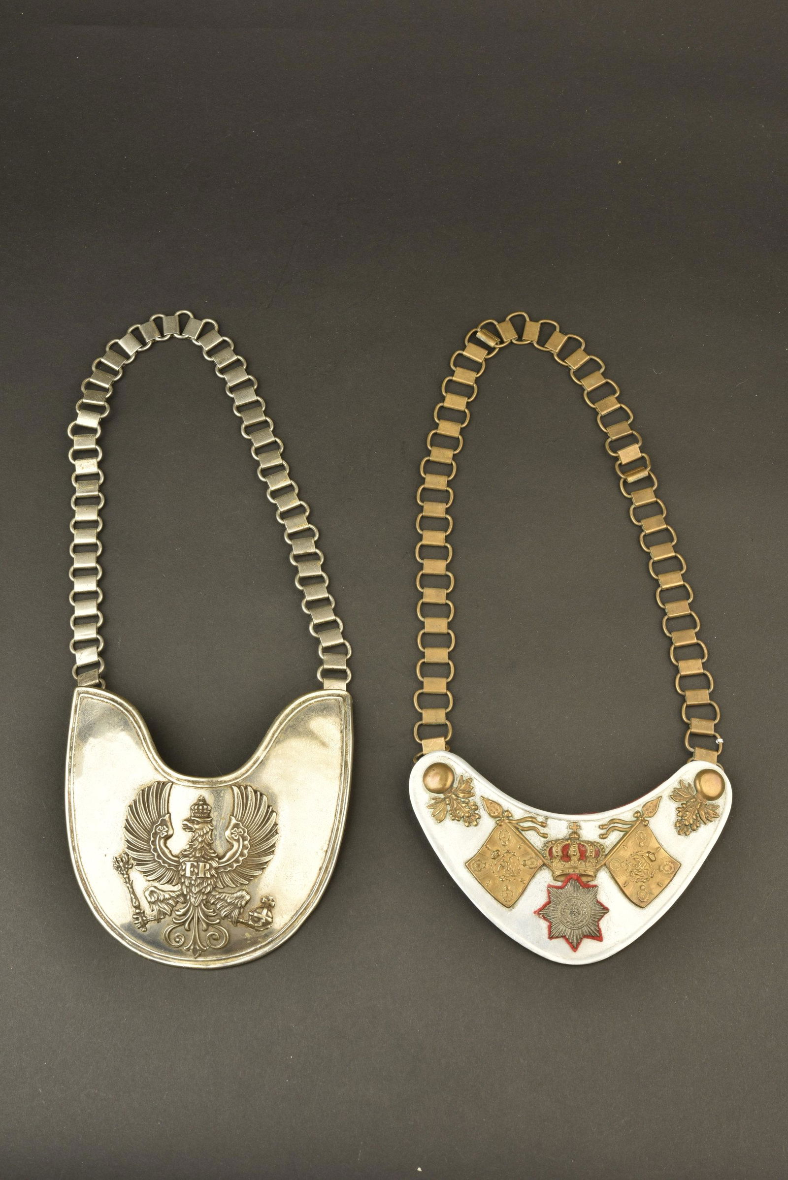 Lot de deux reproductions de hausse-cols prussiens. Lot: Belle reproduction d un Ringkragen de Stabswache avec sa chainette et une reproduction de porte drapeau de la Garde en metal blanc leger avec sa chainette. Lot of 2 replicas gorget, one of the Kaiser