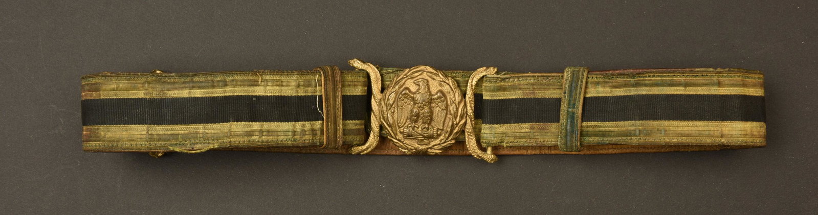 Ceinturon MVSN. MVSN Belt.: Ceinturon en galon or et noir, montes sur un cuir marron. Certaines coutures sont defaites. Boucle en metal dore. Aigle fasciste en relief, fabrication SAFS Napoli. A noter une forte usure et patine d