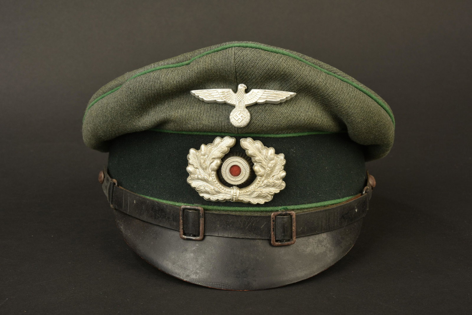 Casquette sous officier administration. NCO: En gabardine Feldgrau, triple lisere vert. Bandeau en drap vert fonce. Insignes metalliques. Les insignes n ont pas ete verifie au dos car ils n ont pas ete demontes. Fausse jugulaire en cuir noir. In