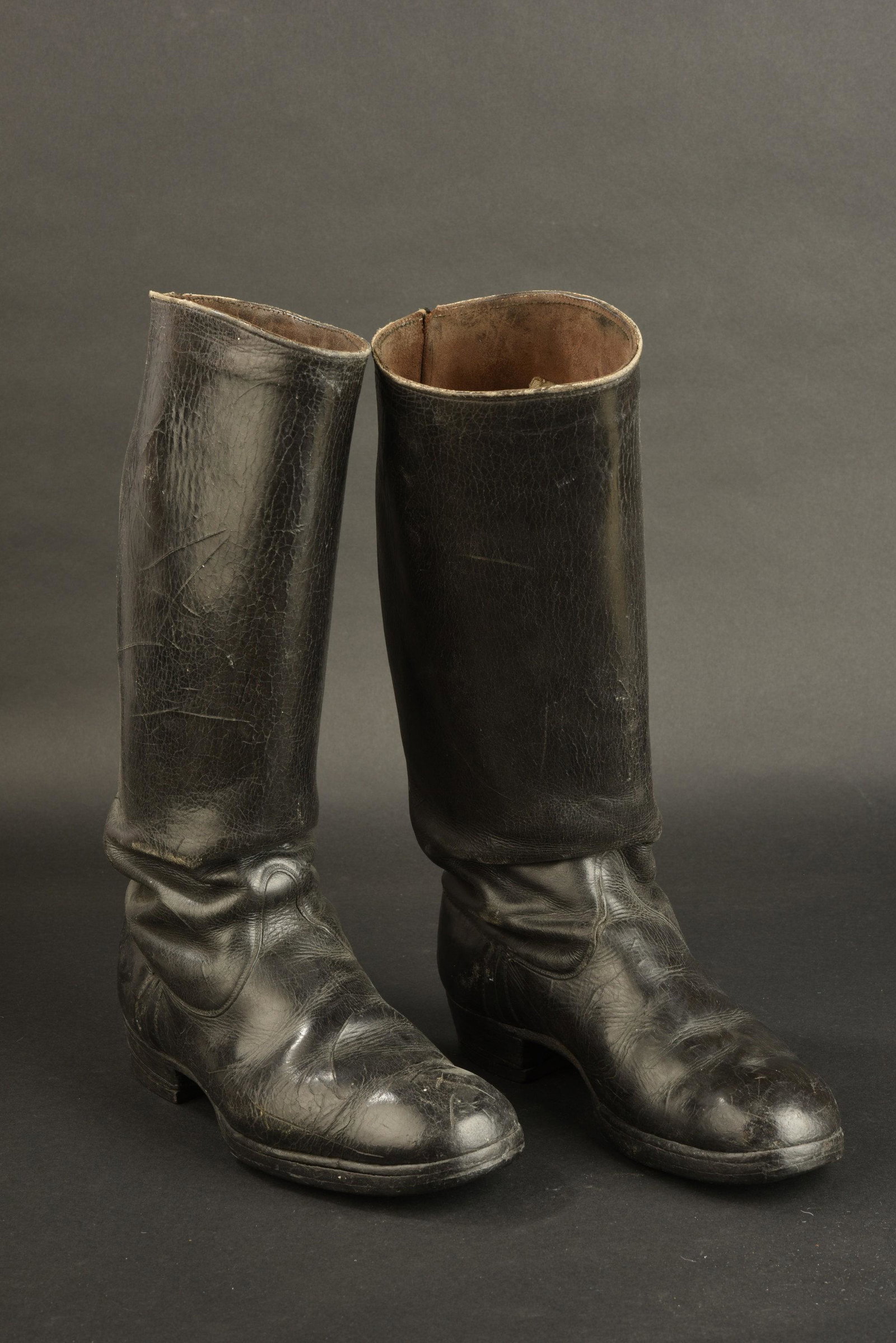 Bottes d officier allemand. German officer boots.: En cuir noir lisse. Tige haute. Paire homogene. Sans marquages visibles. Semelles lisses. Talon en caoutchouc. Deux trous ont ete perces sous la semelle pour permettre la fixation du mannequin sur son