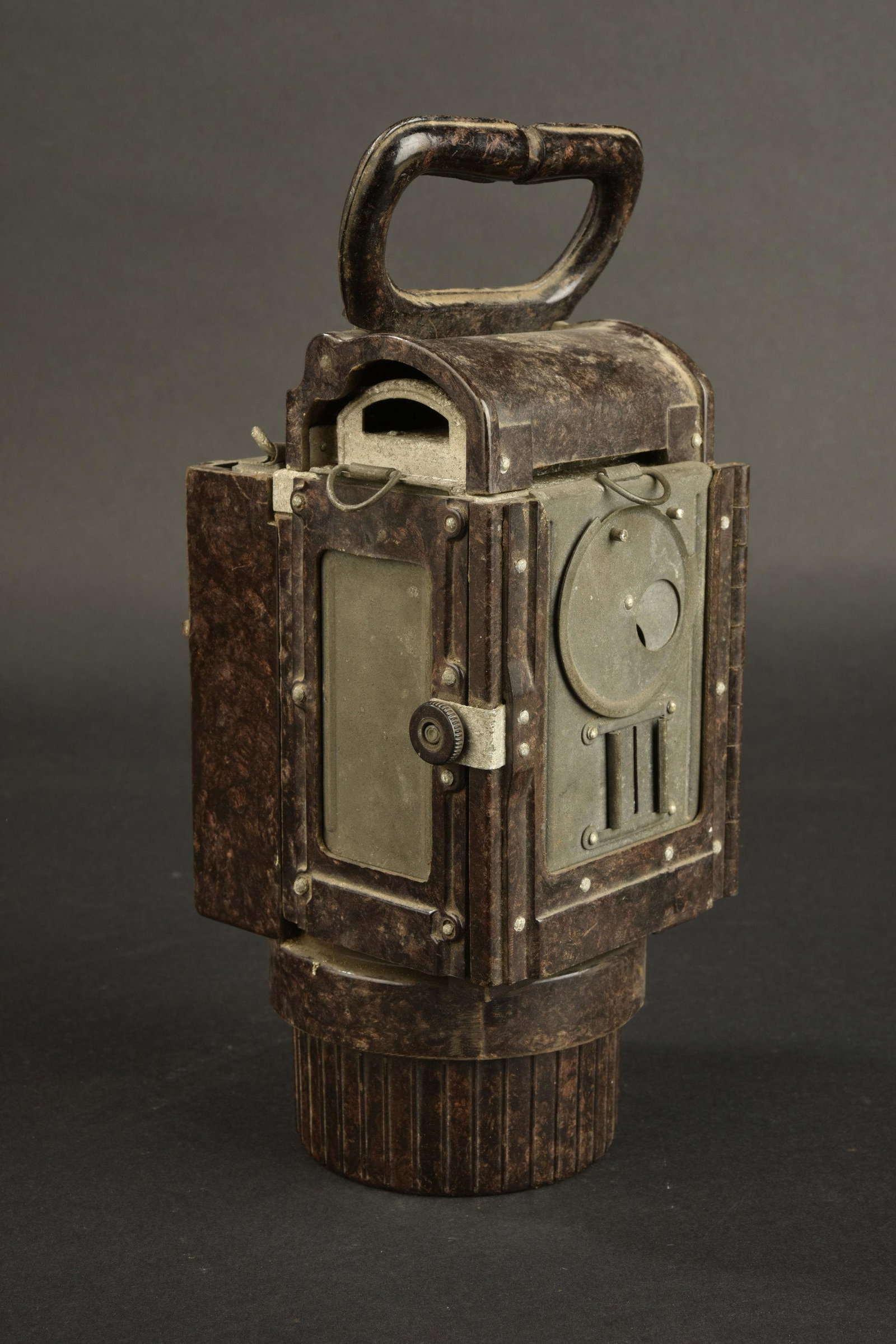 Lanterne bakelite. Bakelite lantern.: En bakelite marron, poignee de transport presente, ainsi que le filtre Ã carbure. Le crochet de suspension est manquant. Les verres sont presents et en tres bon etat. Tous les accessoires sont manq