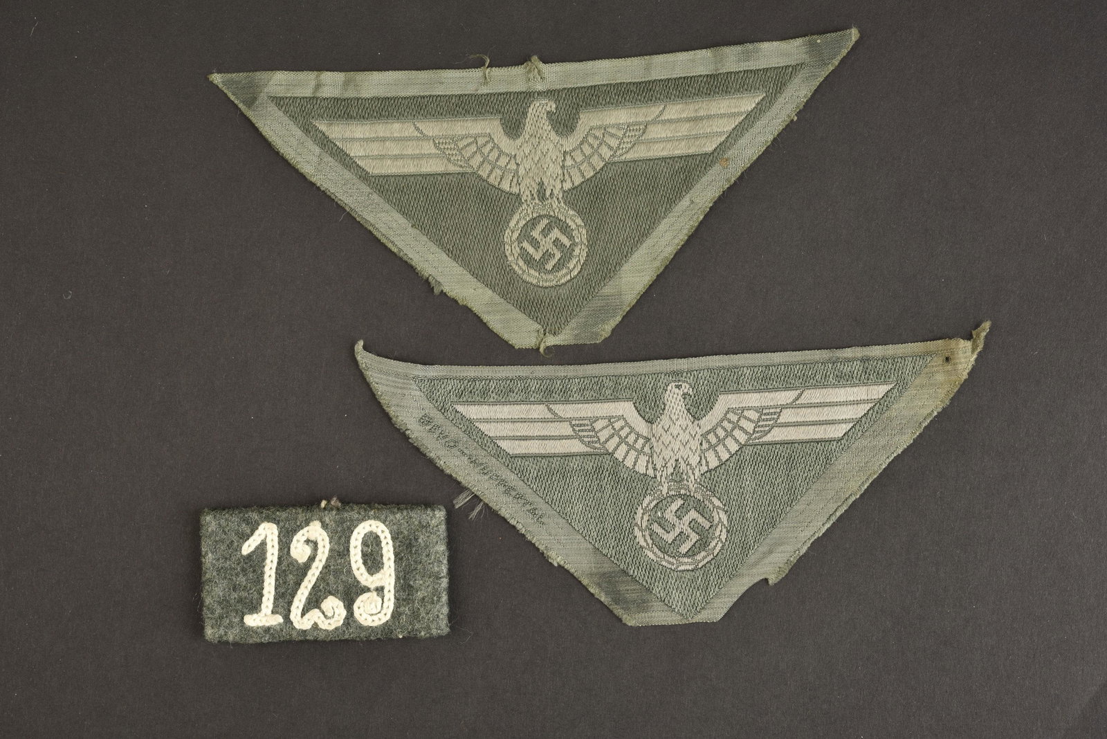 Aigles de poitrine de la Heer. Heer s breast eagles.: Comprenant deux aigles Bevo, jamais montes. Pieces de forme triangulaires. Quelques traces de colle au niveau des bordures des insignes. On y joint un passant de patte d epaule en drap Feldgrau et bro