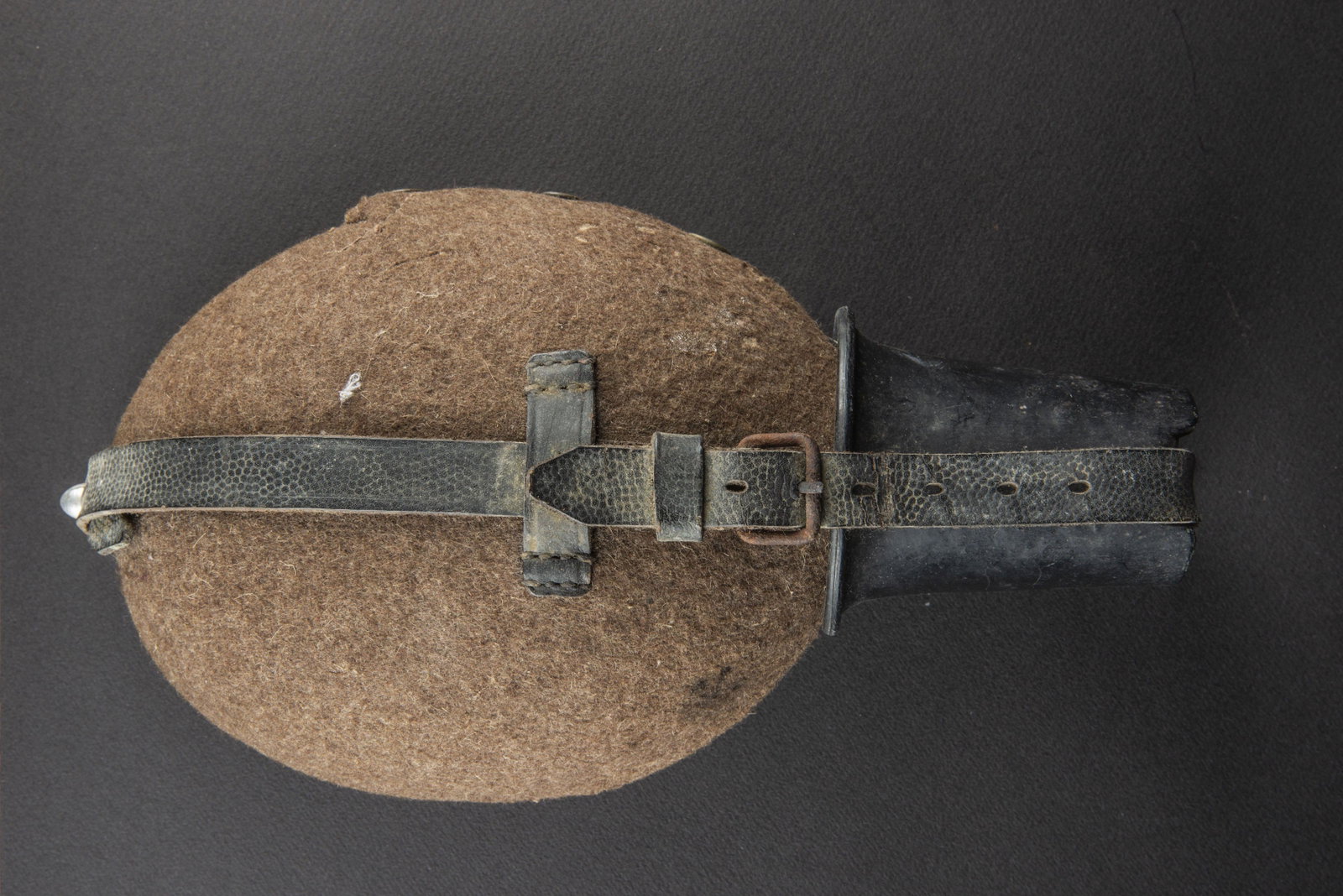 Gourde allemande. German Canteen.: Gourde en metal emaille rouge. Housse en drap Feldgrau, les boutons pression sont fonctionnel. Quart en bakelite noir. Harnais en cuir present et complet, cuir cassant. Mousqueton en metal, partiellem
