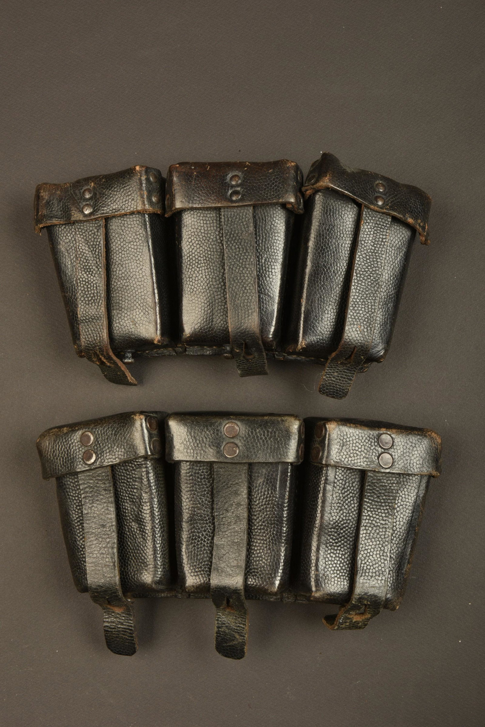 Cartouchieres de Mauser 98K. 98K pouches.: Paire non homogene en cuir grenele noir. Toutes les lanieres sont presentes. Marquages RBNr 0 0676 0038 et 0 0655 0005. A noter une certaine usure et patine des pieces. Provenance du Musee de la Secon