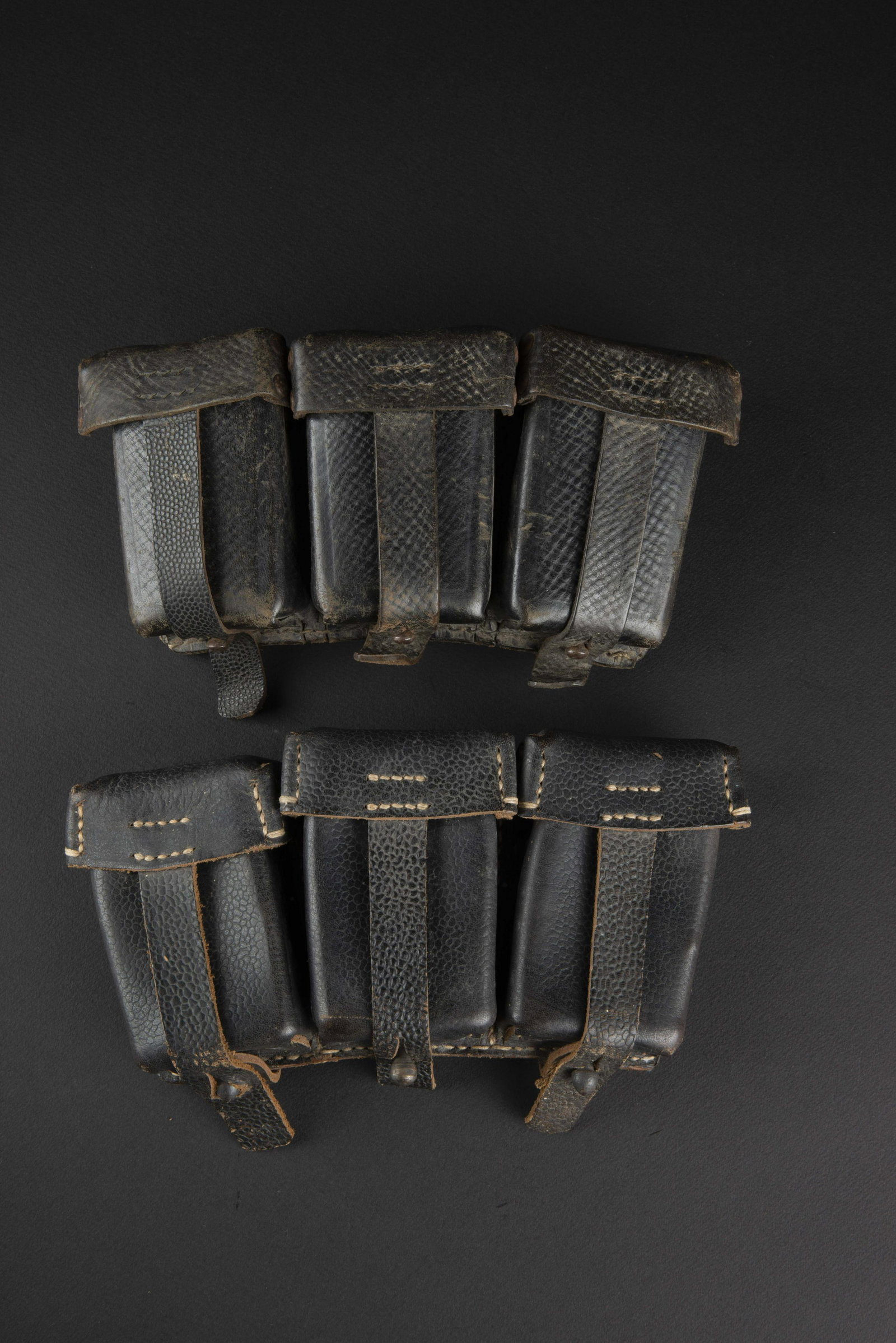 Cartouchieres 98K. 98K pouches.: Deux cartouchieres en cuir grenele noir. Paire non homogene. Toutes les sangles sont presentes. Une cartouchiere est marquee 0 1250 0011 FZGJ 1943. A noter une certaine usure et patine des pieces. Plu