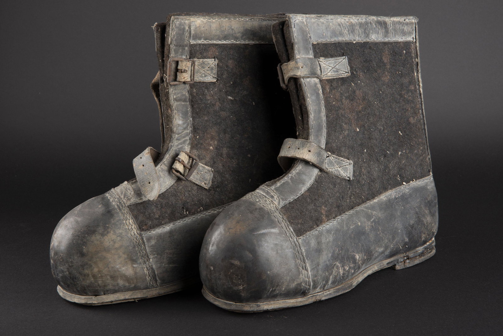 Bottes de garde. Guard boots.: En feutre et cuir noir. Les deux sangles de fermeture sont presentes. Paire homogene. Semelle en cuir marron, marquee 30. Etiquette du fabricant Paul Otto Hartha 1941. A noter une certaine usure et pa