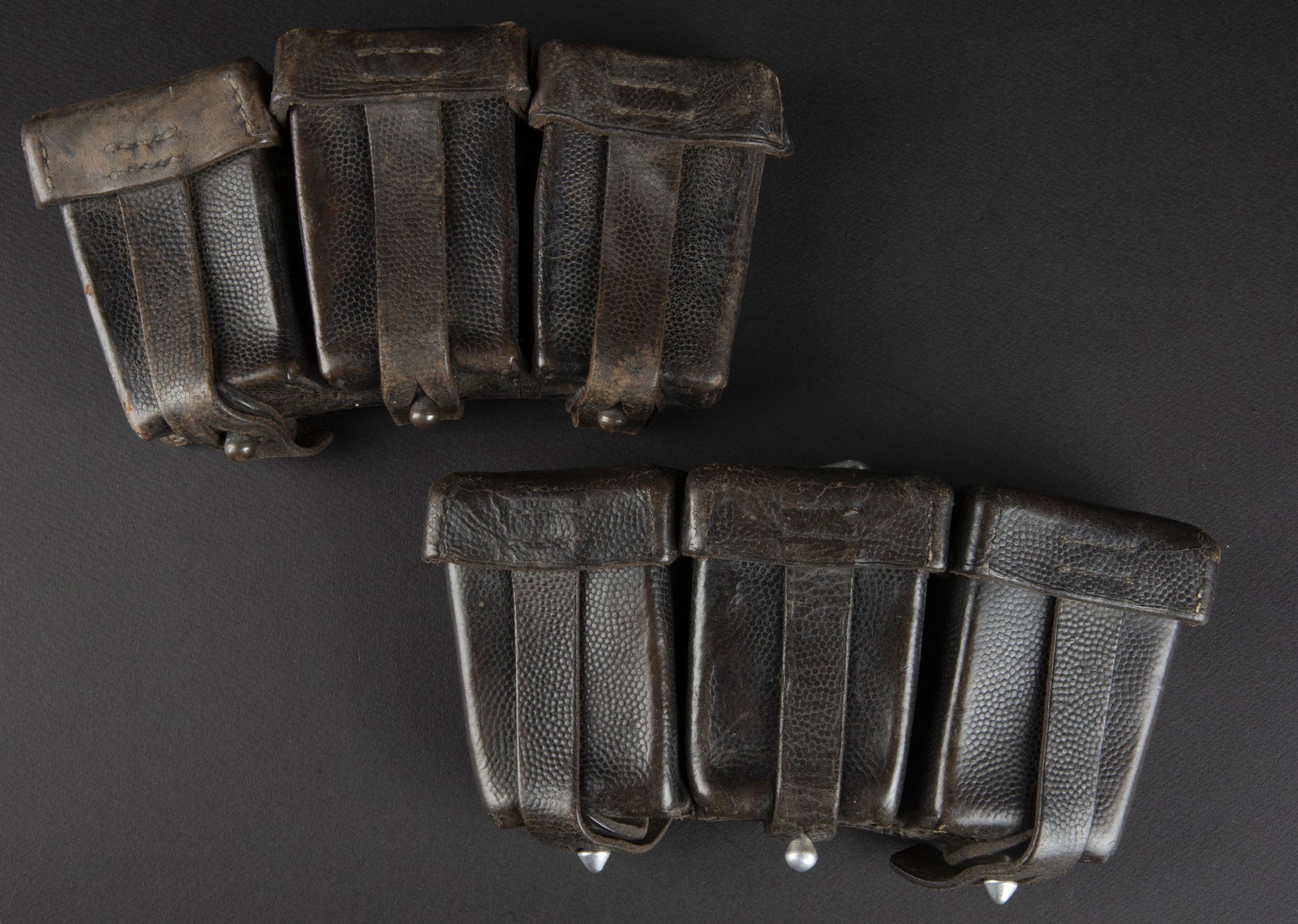 Cartouchieres de Mauser 98K. 98K pouches.: Deux cartouchieres en cuir grenele noir. Paire non homogene. Bouclerie en metal et aluminium. Restes de marquages illisibles. A noter une certaine usure et patine des pieces. Plus de photos sur aiolfi