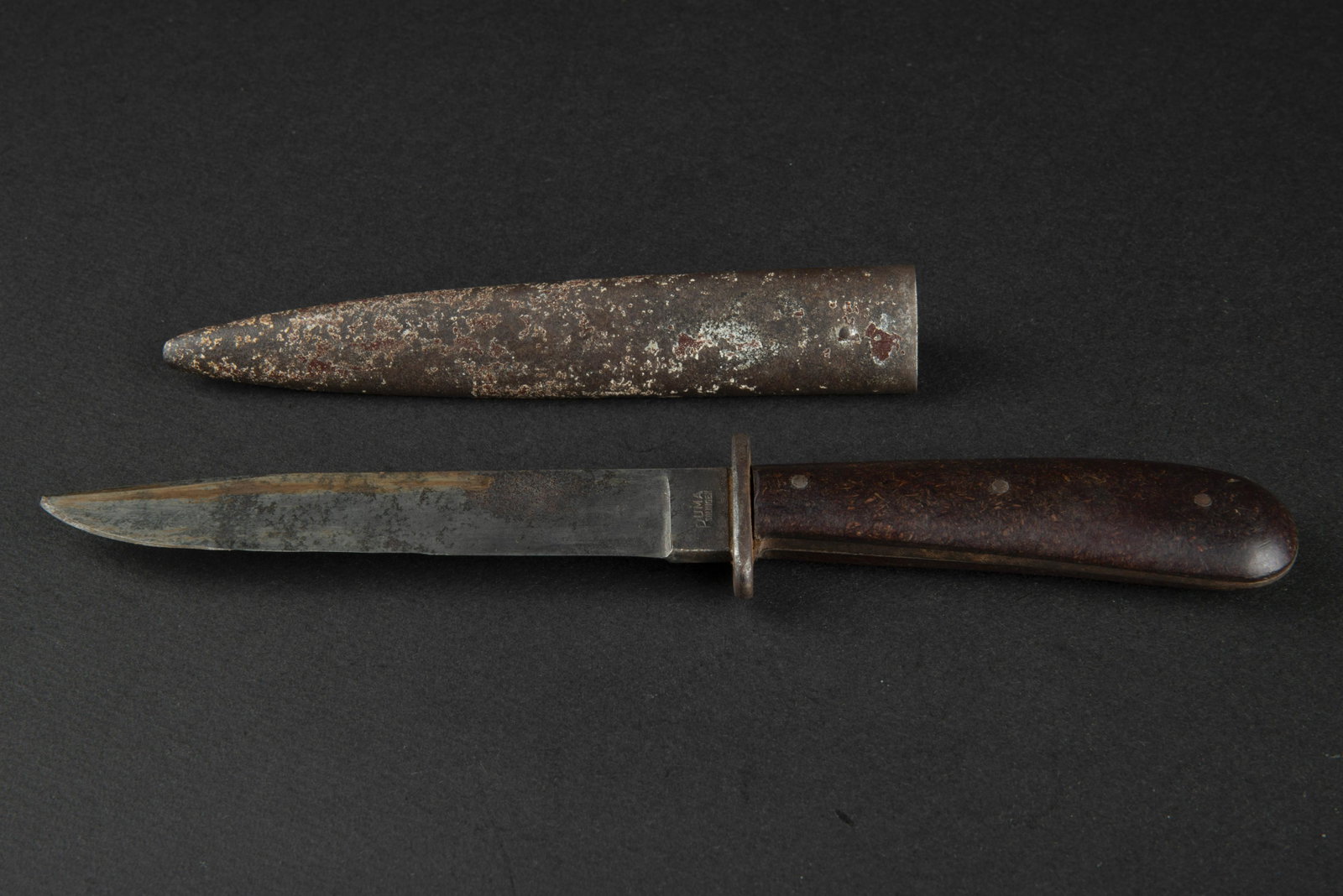 Couteau de botte Puma. Puma boot knife.: Plaquettes en bakelite marron, maintenues par trois rivets. Toutes les garnitures metalliques sont partiellement oxydees. Lame oxydee, affÃ»tee et visiblement raccourcie. Marquages Puma Solingen. Fo