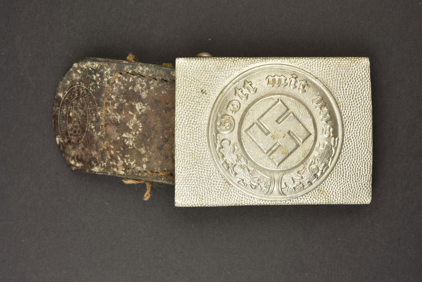 Boucle de ceinturon Polizei. Polizei belt buckle.: En aluminium, insigne en relief. Sans marquages visibles. Pattes en cuir presente, mais incomplete, datee 1938. A noter une certaine usure et patine de la piece. Plus de photos sur aiolfi.com. Aluminu