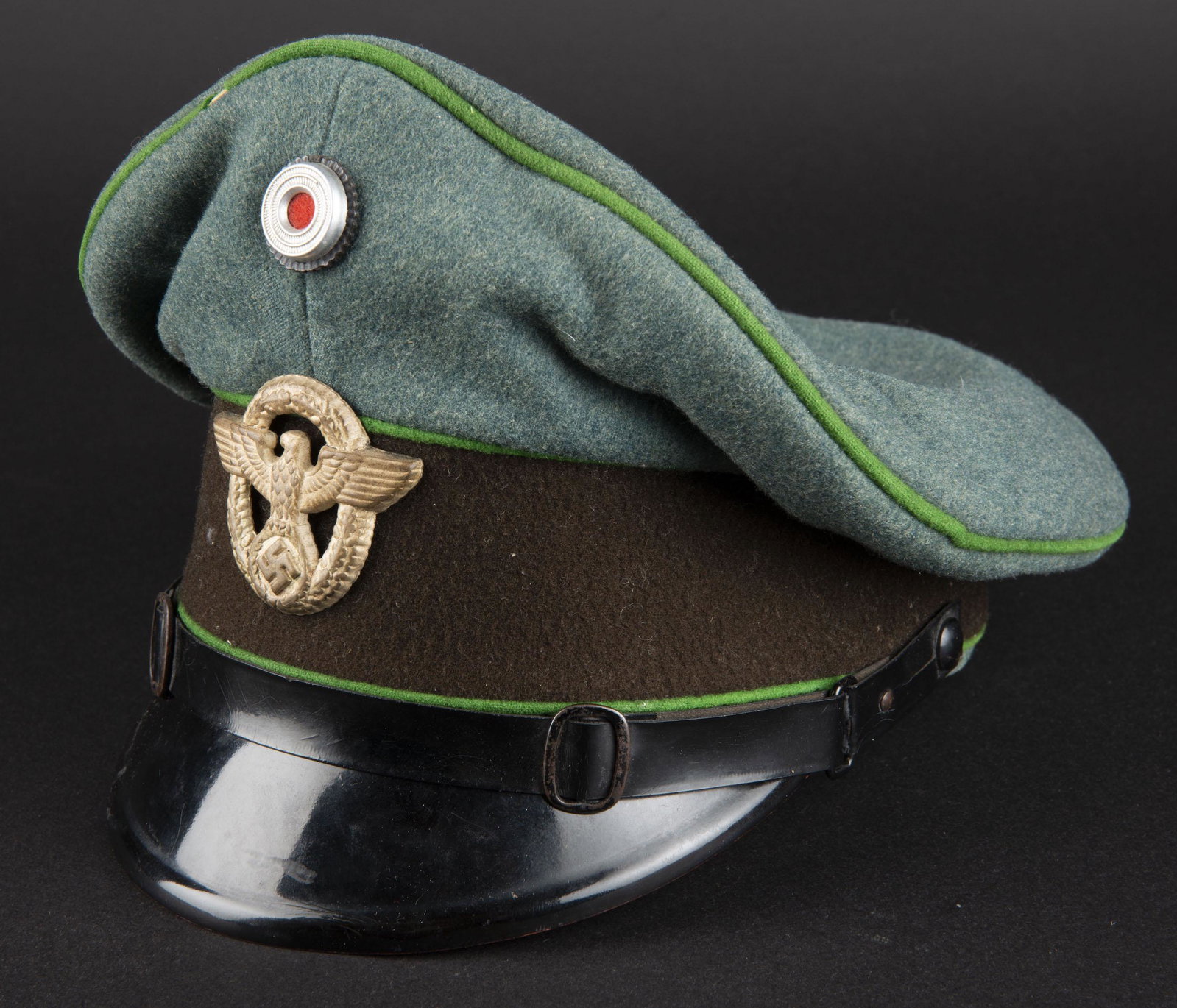 Caquette sous officier ORPO. Orpo NCO cap.: En drap gris vert. Triple lisere vert. Bandeau marron fonce. Cocarde metallique, insigne Polizei du second type en metal. Les insignes n ont pas pu etre verifies au dos car ils n ont pas ete demontes.