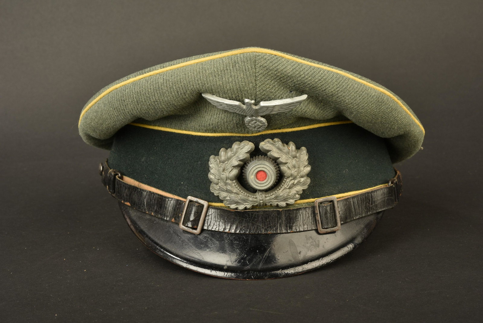Casquette de sous officier transmission. NCO: En gabardine Feldgrau, triple lisere jaune citron, typique des unites de transmission. Aigle en metal, une attache est manquante. Cocarde et feuilles de chene en metal. Les insignes n ont pas ete veri