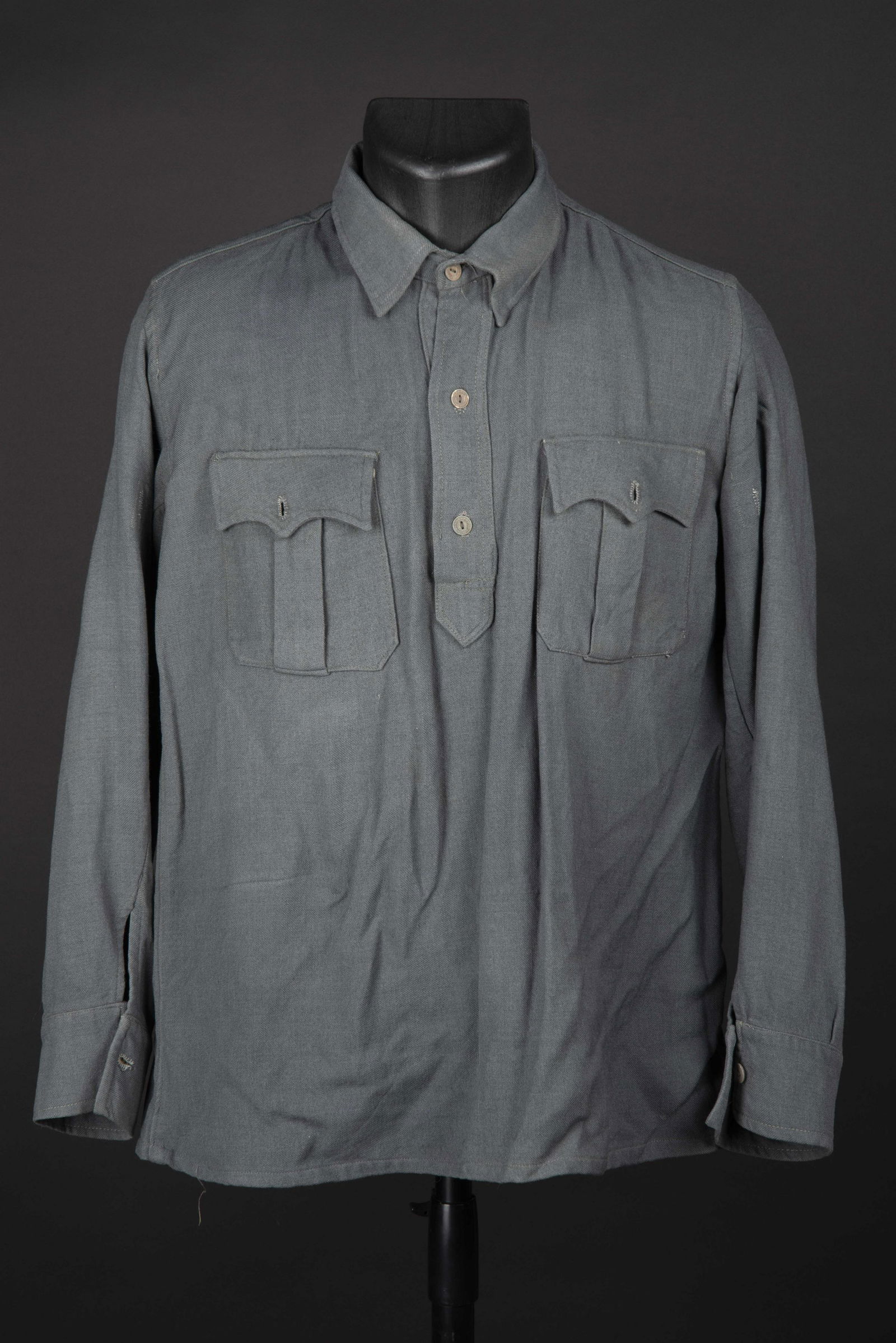 Chemise Aertex.: En tissu coton gris, tous les boutons cartonnes sont presents. Sans marquages visibles. Petite taille. A noter une legere usure et patine de la piece. Plus de photos sur aiolfi.com. In gray cotton fab