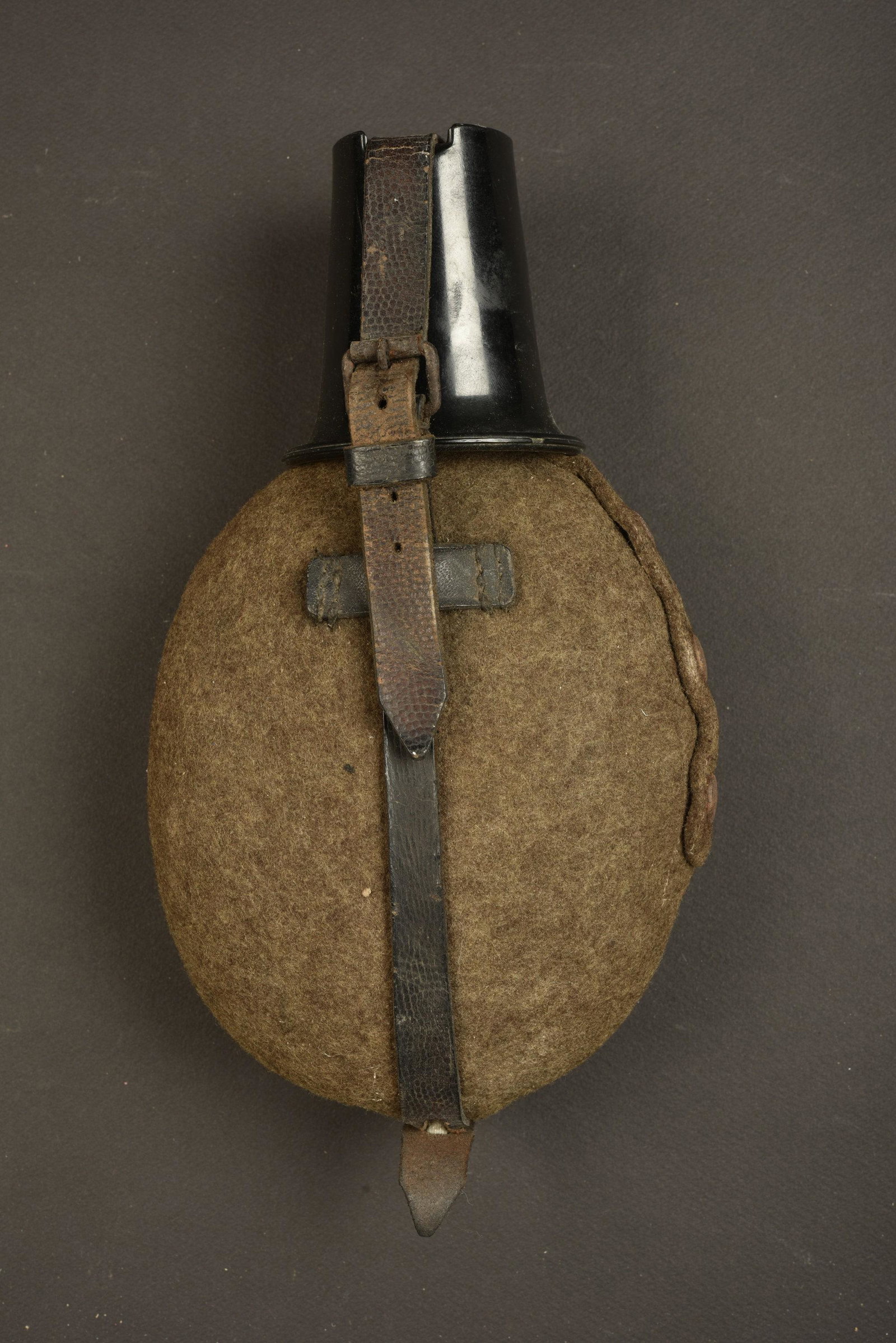 Gourde allemande. German canteen.: Gourde en aluminium. Complete. Housse en feutrine mitee. Harnais en cuir complet, mousqueton fonctionnel et oxyde. Quart en bakelite. A noter une certaine usure et patine de la piece. Plus de photos s