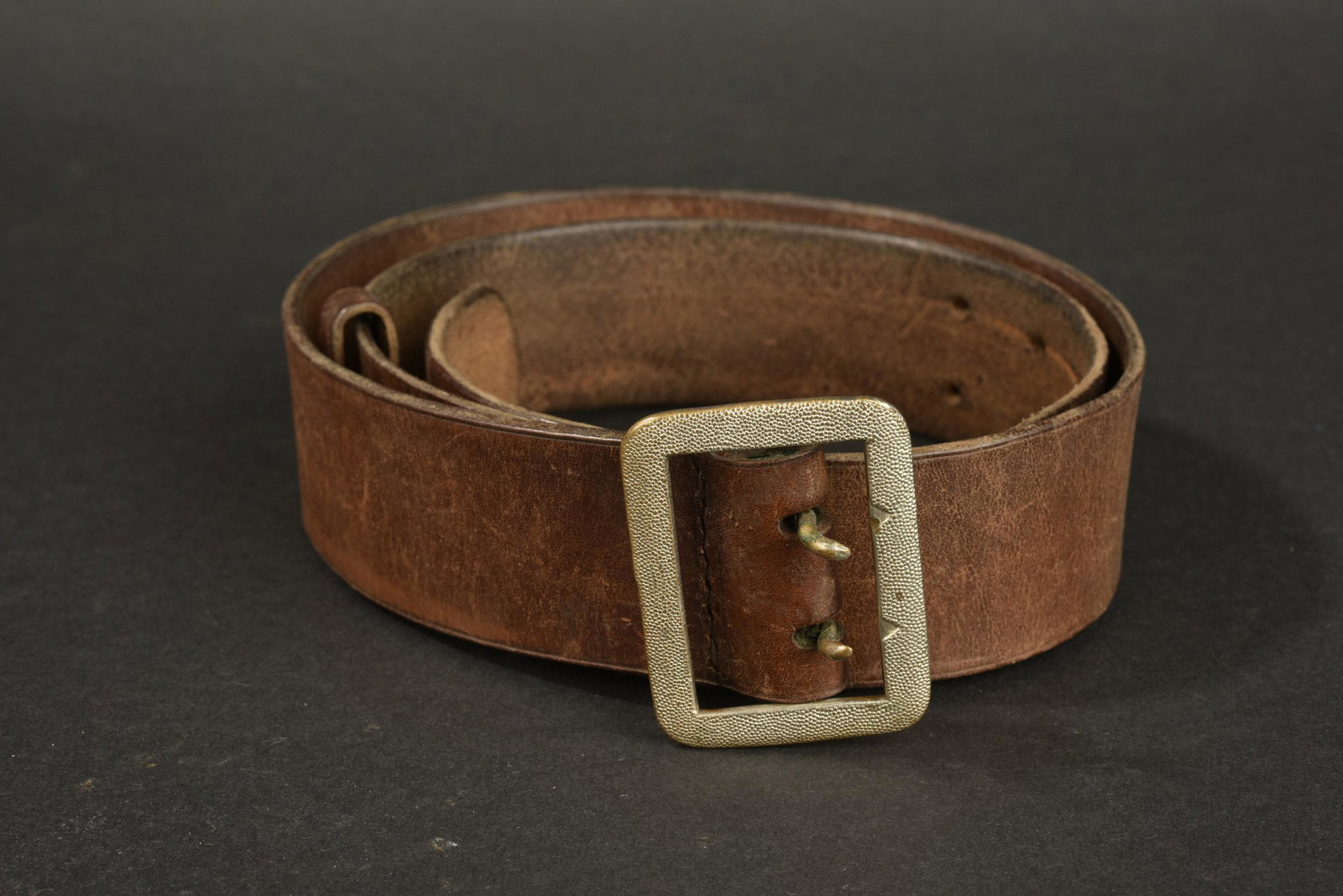 Ceinturon officier de la Luftwaffe. Luftwaffe officer: En cuir marron, boucle a deux ardillons en metal grenele. Sans marquages visibles. A noter une certaine usure et patine de la piece. Provenance du Musee de la Seconde Guerre Mondiale a Tosny en Norman