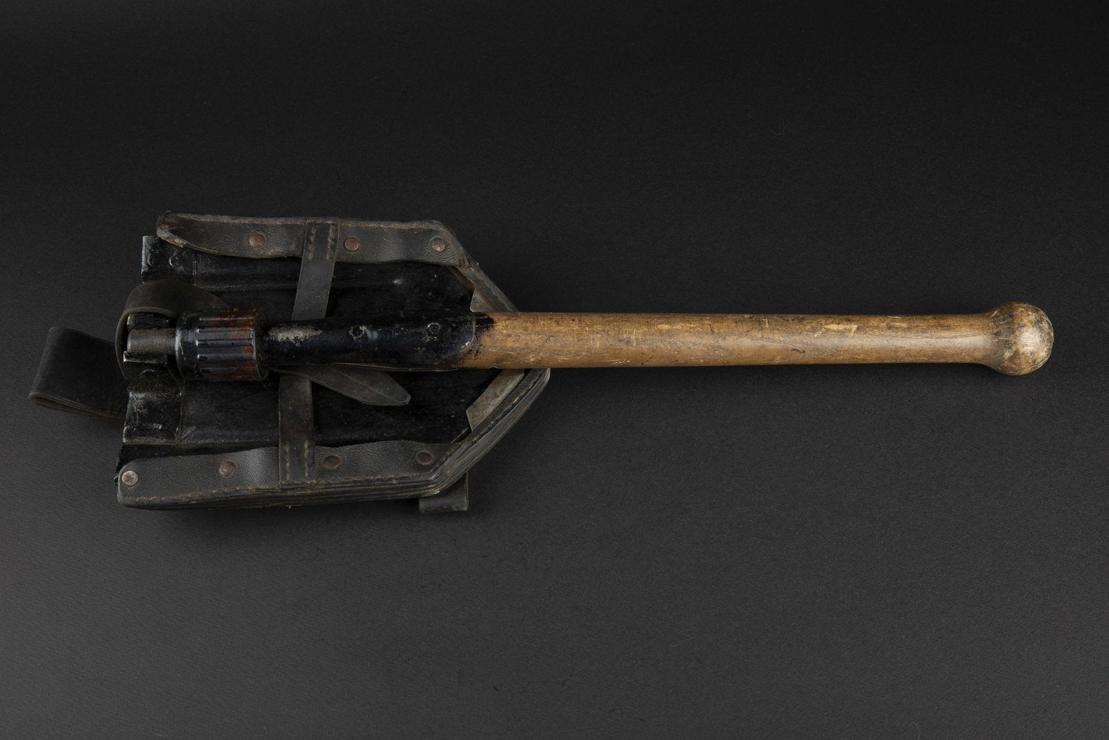 Pelle et porte pelle. Shovel and cover.: Manche en bois, partie metallique pliante, fonctionnelle, repeinte en noir. Vis en bakelite marron. Porte pelle en cuir noir, et renfort en metal. Sangle de fermeture complete, ainsi que le passant de
