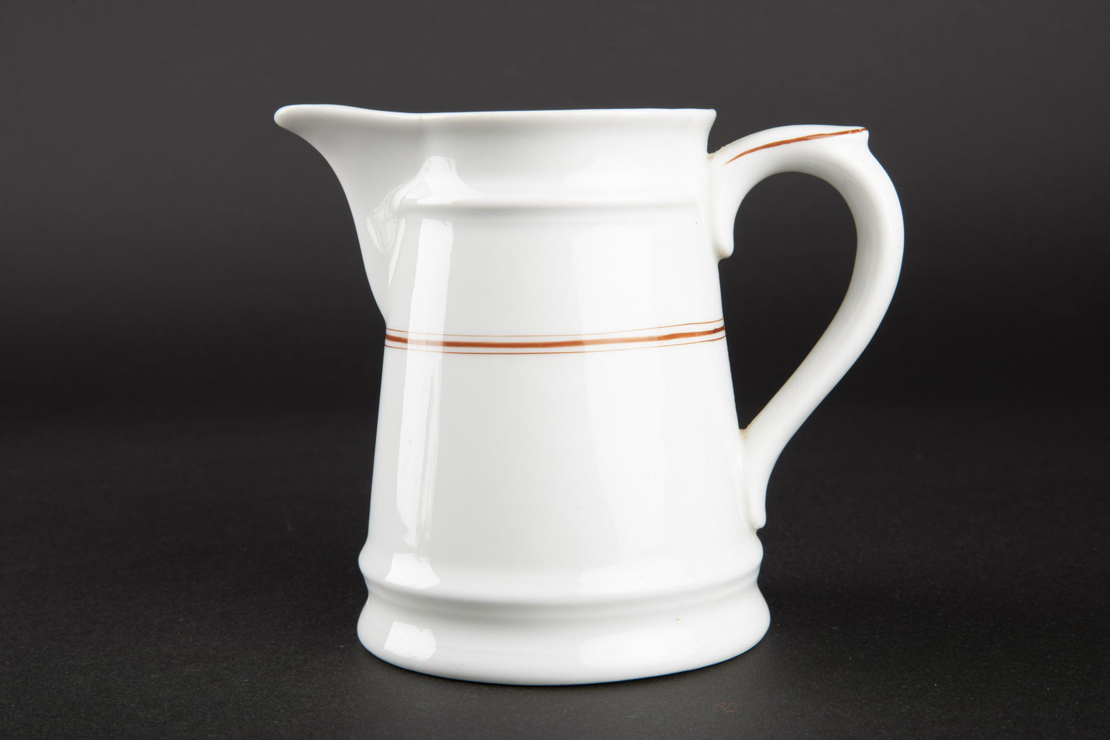 Pot a lait Kriegsmarine. Kriegsmarine milk jug.: En porcelaine blanche, double lisere rouge. Anse complete Bec verseur pas casse. Le lisere rouge correspond a la vaisselle du mess des sous officier. Beau marquage KM, fabrication KPM 1941. A noter un