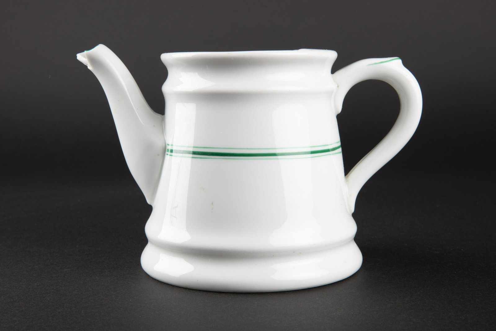 Theiere Kriegsmarine. Kriegsmarine teapot.: En porcelaine blanche, double lisere vert. Anse complete. Bec verseur presentant un manque. Couvercle manquant. Fabrication Koenigszelt 1942. Le lisere vert correspond au mess des officiers. A noter u