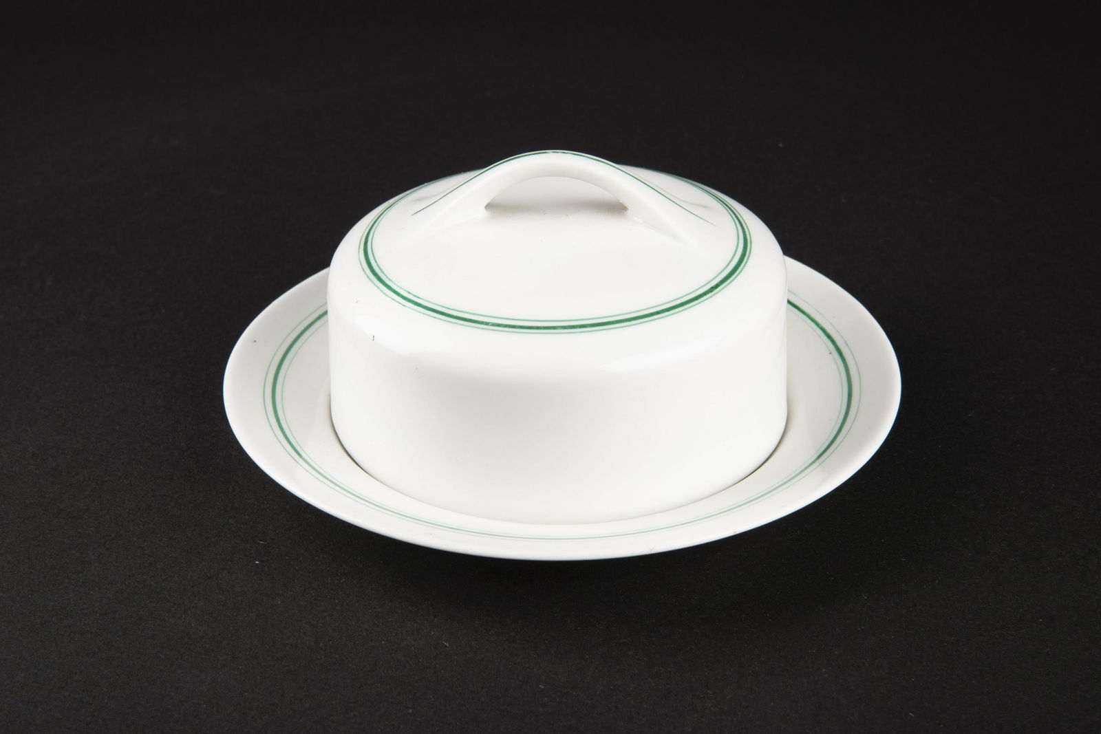 Beurrier Kriegsmarine. Kriegsmarine butter dish.: En porcelaine blanche, assiette et couvercle presents. Double lisere vert. Le lisere vert correspond au mess des officiers. Poigne du couvercle complete. Beau marquage Kriegsmarine. Fabrication KPM 19