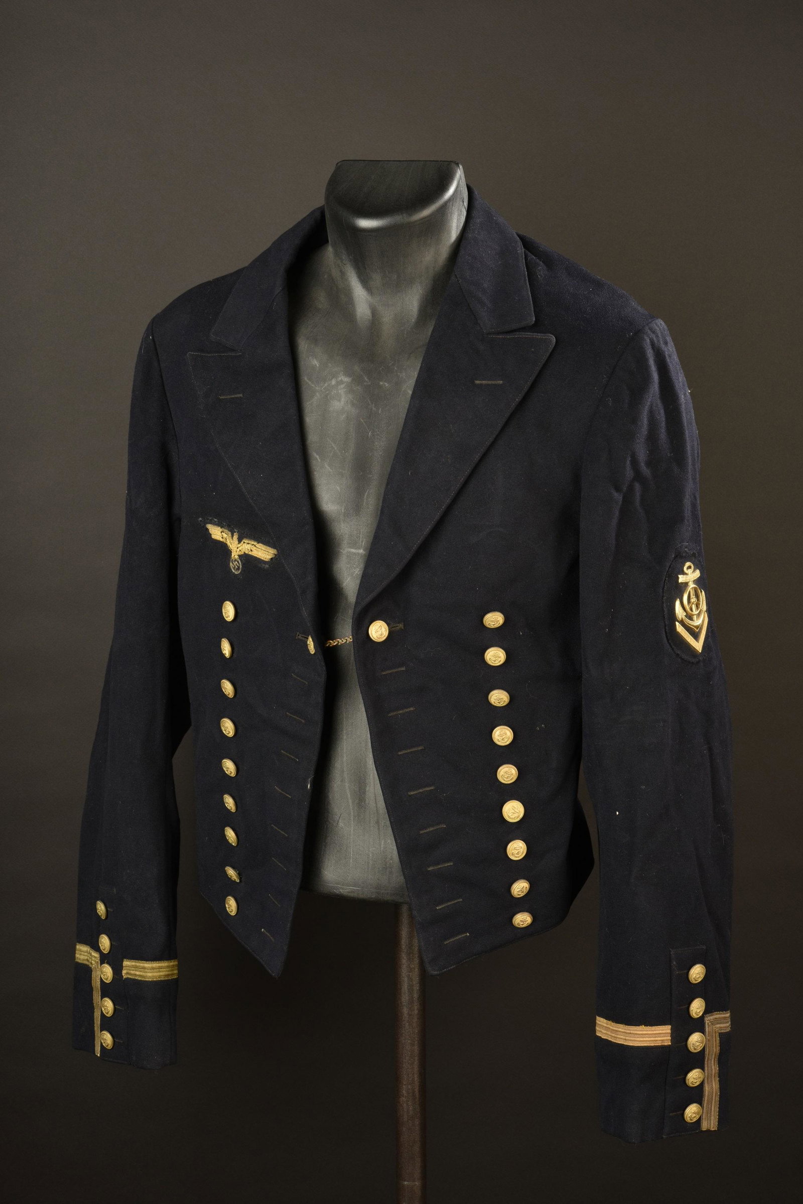 Spencer KM. Kriegsmarine NCO spencer.: En drap bleu marine. Tous les boutons sont presents et estampilles de l ancre de marine. ChaÃ®nette presente. Aigle de poitrine d officier en cannetille or, monte main. Insigne de manche de second m