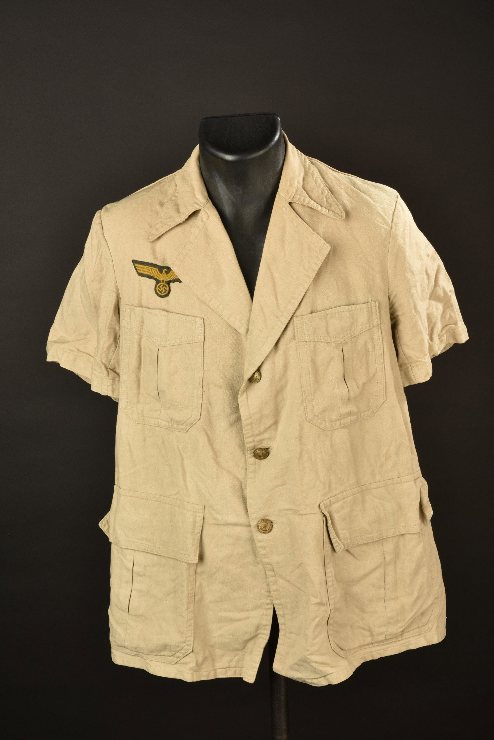 Chemise Kriegsmarine. KM shirt.: Chemisette en tissu coton beige. Manches courtes. Ce modele de chemisette n est pas garantie d origine. Modele fantaisie. Tous les boutons sont presents et estampilles de l ancre de marine. Aigle Krie