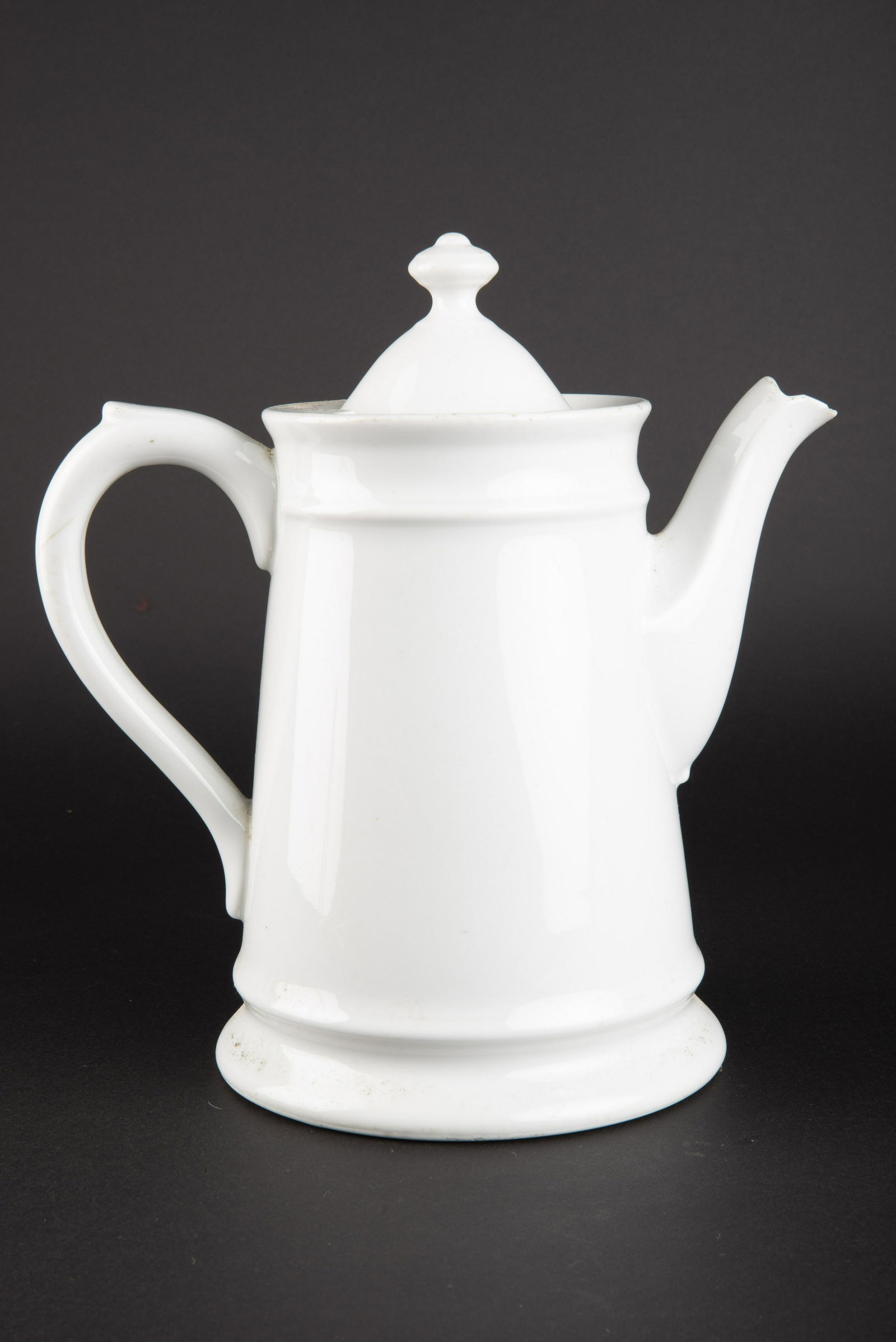 Cafetiere KM. Kriegsmarine coffee maker.: En porcelaine blanche. Anse complete, couvercle present. Hauteur 23 cm. Bec verseur presentant quelques manques. Fabrication KPM 1942. A noter une certaine usure et patine de la piece, ainsi que quelq