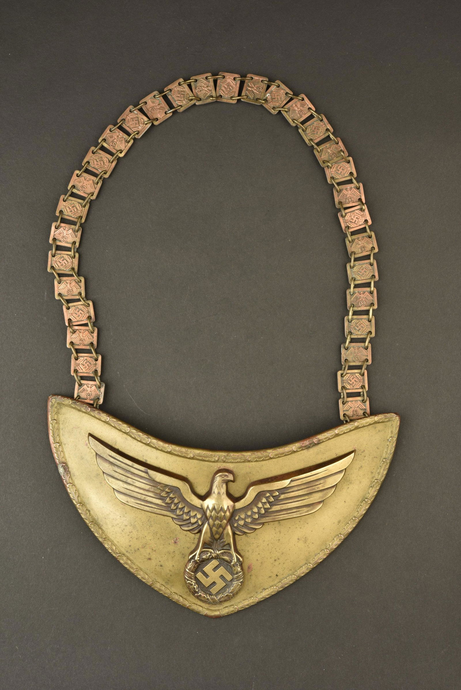 Hausse col NSDAP. NSDAP gorget.: Hausse col en laiton, aigle national rapporte. ChaÃ®nette complete, alternant un aigle et un insigne national. Dos de la piece, double en drap marron, comportant de nombreux trous de mite. Pattes ma