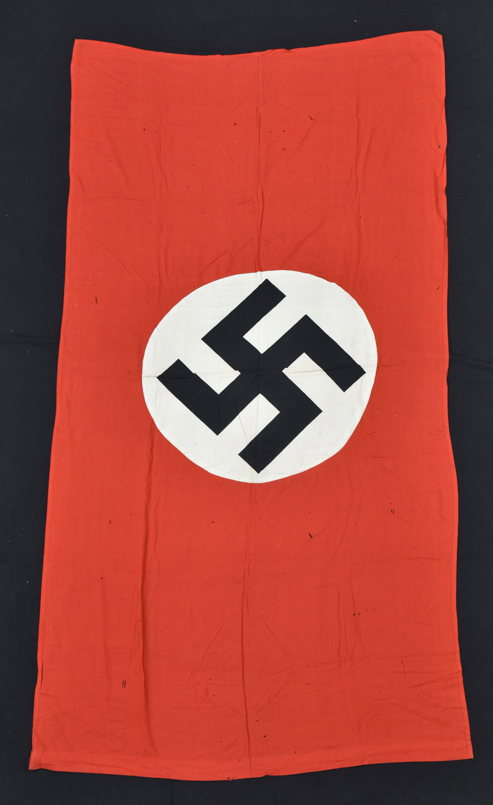 Drapeau allemand de Poitiers. German flag of Poitiers.: En tissu coton rouge. Biface, insignes rapportes et imprimes. Passant pour mat present. Sans marquages visibles. Dimensions 119 x 246 cm. A noter une certaine usure et patine de la piece, ainsi que qu