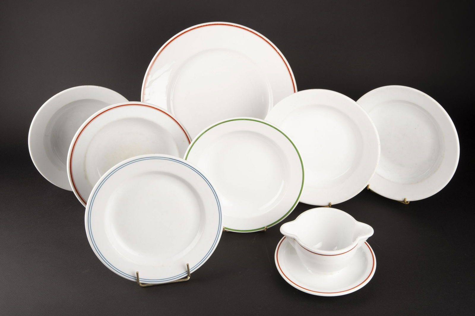 Vaisselle du DAF. DAF tableware.: Comprenant un grand plat rond, en porcelaine blanche, lisere rouge, diametre 33 cm, insigne du DAF RAD, fabrication Rosenthal. Une assiette plate, lisere bleu, insigne du DAF, fabrication KPM. Une ass