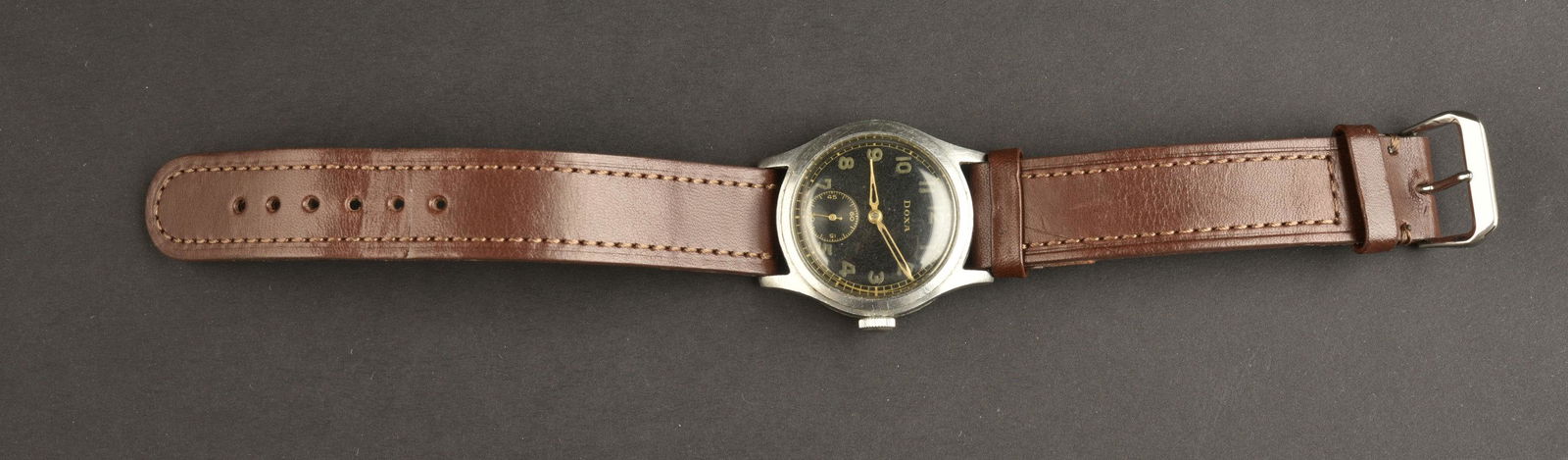Montre de la Heer. Watch from the Heer: Montre de la Heer. Fonctionnelle, cadran en verre presentant quelques rayures. Fond noir, fabrication DOXA, numero D49148 H. Bracelet en cuir marron de fabrication plutot moderne. A noter une certaine