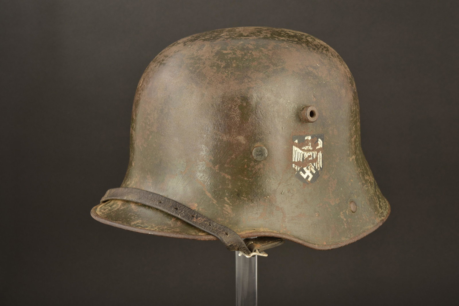 Casque WWI reconditionne.: Casque WWI reconditionne. Coque de casque WWI, fabrication Q66. Pas de numero de lot visible. Peinture reconditionnee Heer appliquee au pinceau a 50%. Insigne de la Heer, a 50%. Coiffe en cuir Reichsw