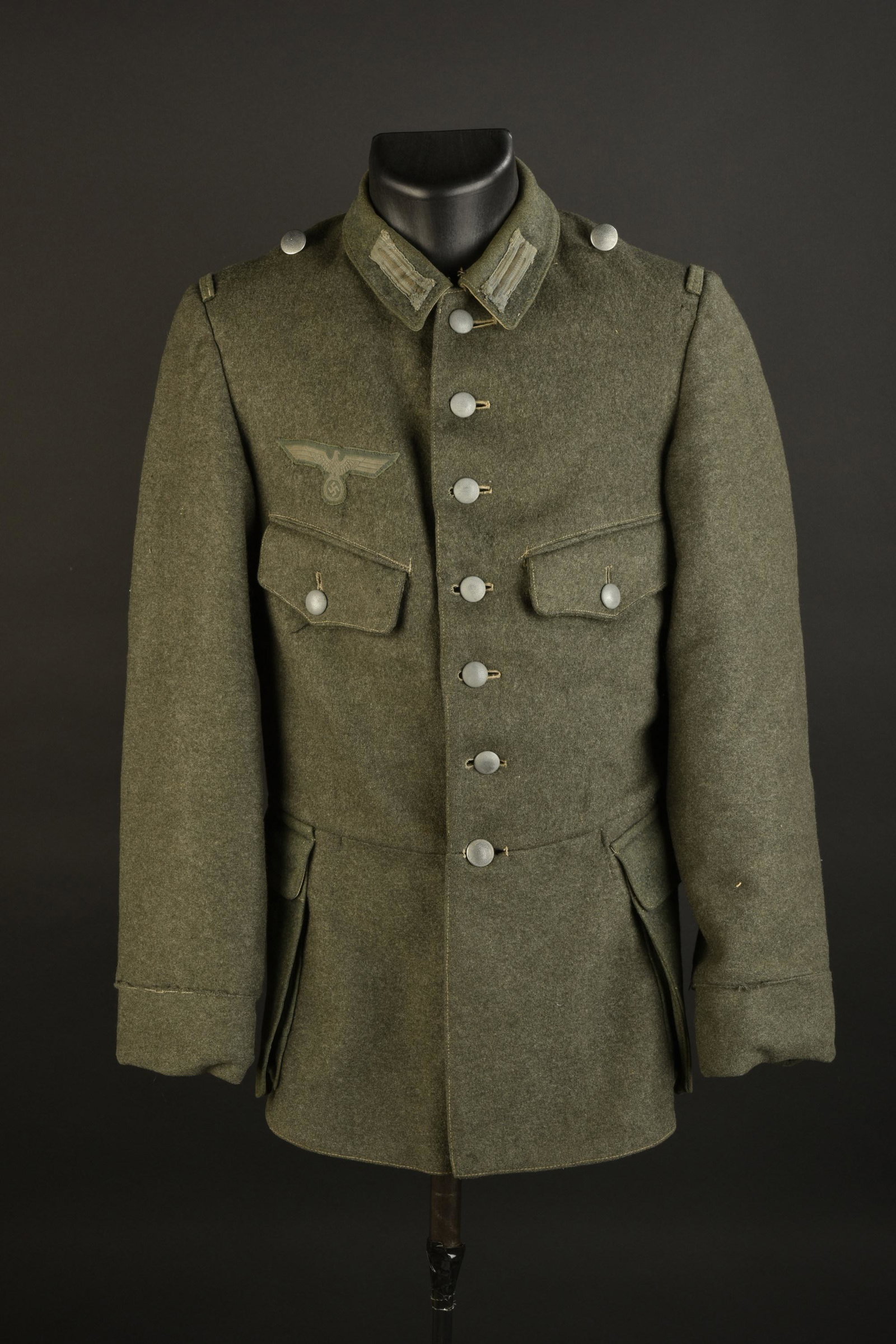 Vareuse allemande. German Jacket.: Vareuse allemande. Modele hollandais recupere par l armee allemande. En drap Feldgrau. Tous les boutons sont presents. Depourvue de pattes d epaule. Litzens montes main. Aigle de poitrine Bevo monte m