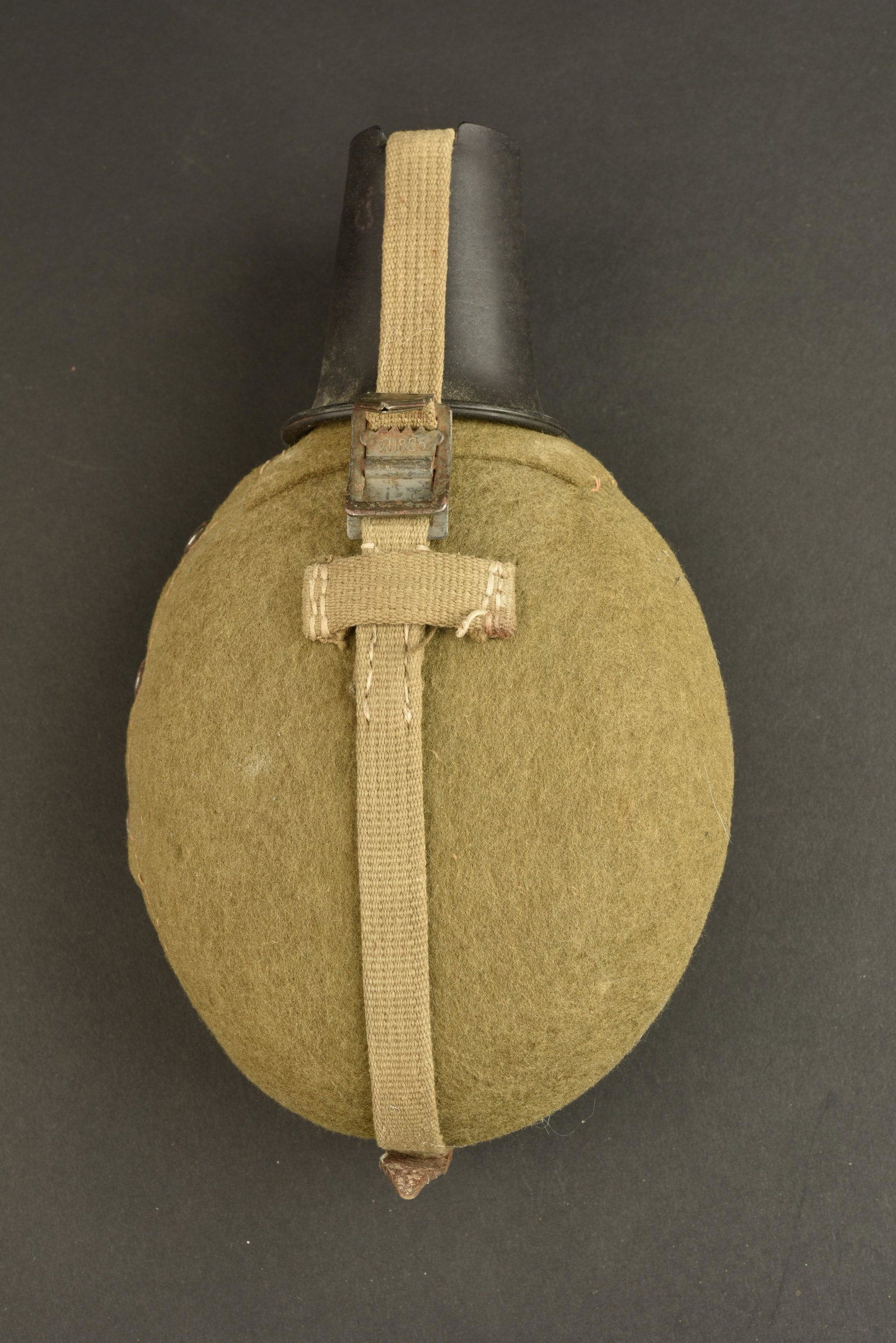 Gourde allemande. German canteen: Gourde allemande. Gourde en aluminium, marquee WAL 41. Bouchon en bakelite complet. Housse en feutrine, disposant d un renfort au dos de la piece. Harnais en toile. Mousqueton complet et fonctionnel. 