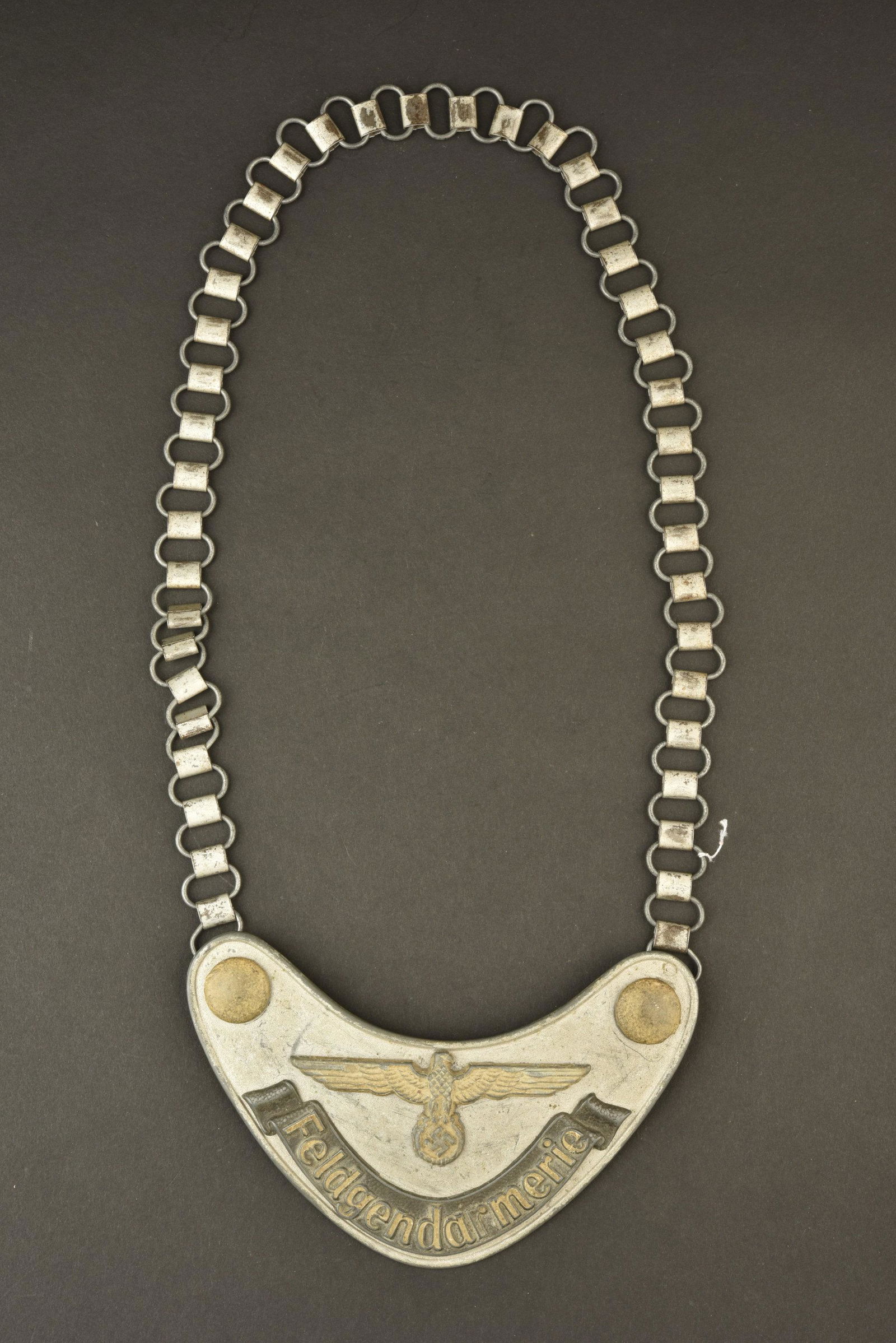 Hausse col Feldgendarmerie terrain. Feldgendarmerie gorget.: Hausse col Feldgendarmerie terrain. En aluminium. Bouton, l aigle, les boutons, et la mention Feldgendarmerie sont phosphorescent. Reste de peinture a 40%. Chainette complete. Doublure en drap vert, q