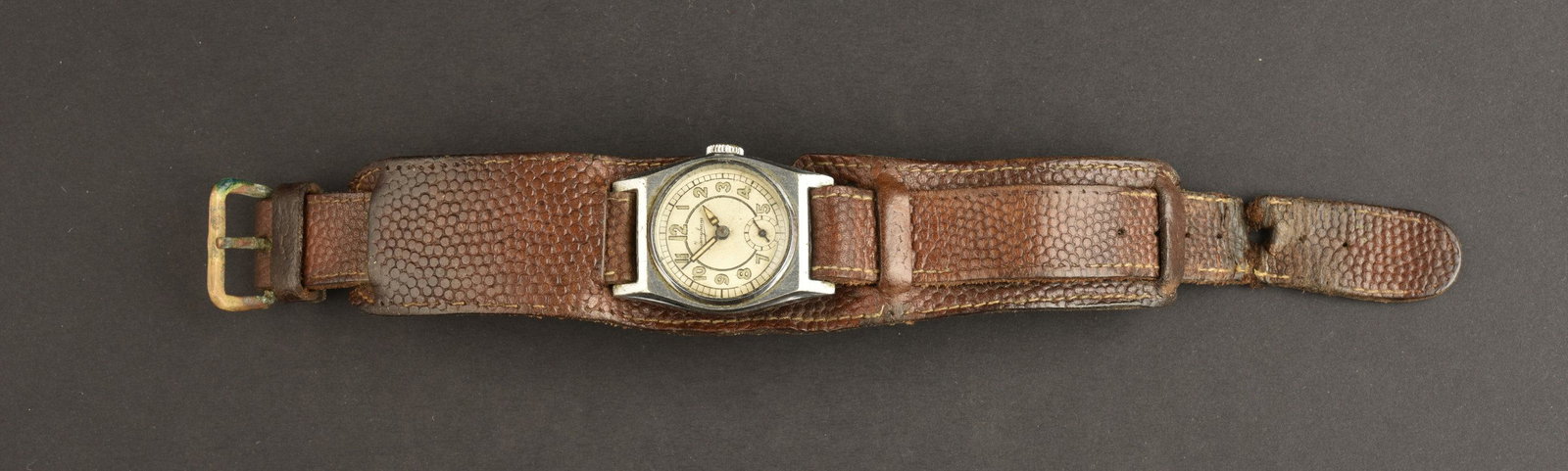 Montre de la Heer. Watch from the Heer.: Montre de la Heer. Non fonctionnelle, fabrication Junghans. Bracelet en cuir marron, presentant des marques d usures et des dechirures. Boucle a un ardillon, complete. Renfort en cuir sur toute la lon