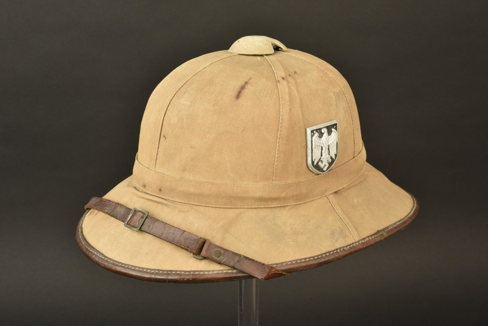 Casque tropical Heer. Heer tropical helmet.: Casque tropical Heer. Premier modele. En toile ecrue. Insignes metalliques presents. Les insignes n ont pas ete demontes, afin de verifier les pattes de fixation. Jugulaire en cuir complete, cuir craq