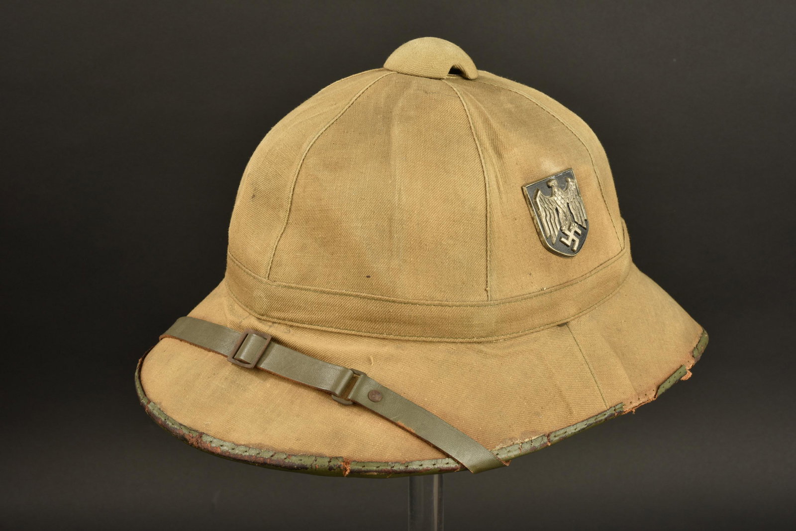 Casque tropical Heer. Heer tropical helmet.: Casque tropical Heer. Premier modele. En toile couleur sable. Insignes metalliques presents. Les insignes n ont pas ete demontes, afin de verifier les pattes de fixation. Jugulaire en cuir complete. Q